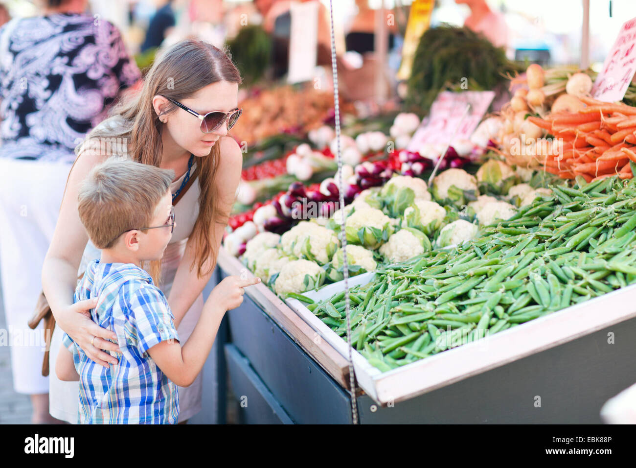 Madre e figlio acquisto di piselli verdi in un mercato ortofrutticolo Foto Stock