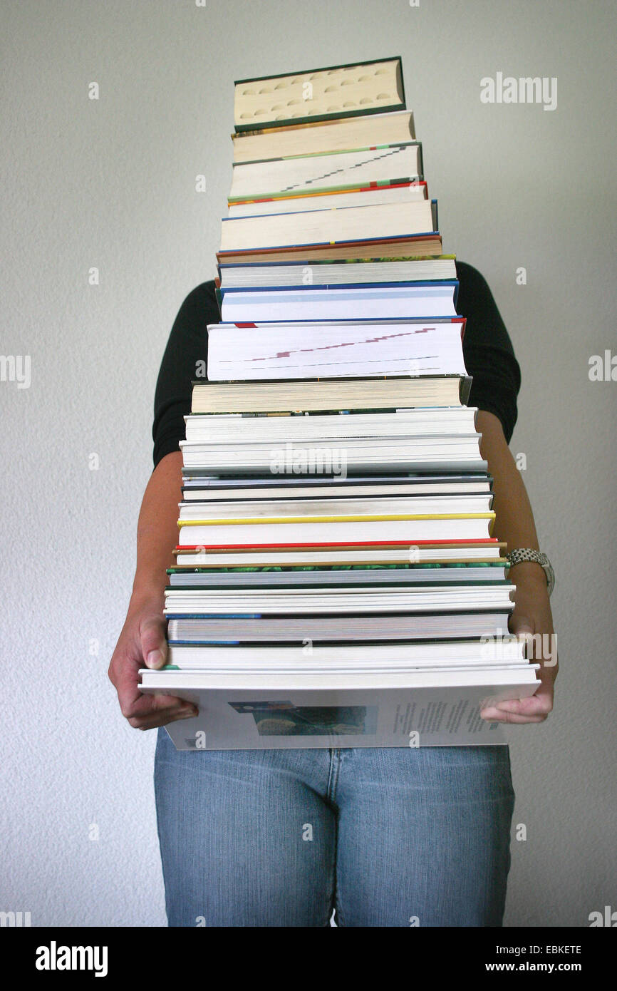 La donna che porta una pila di libri Foto Stock