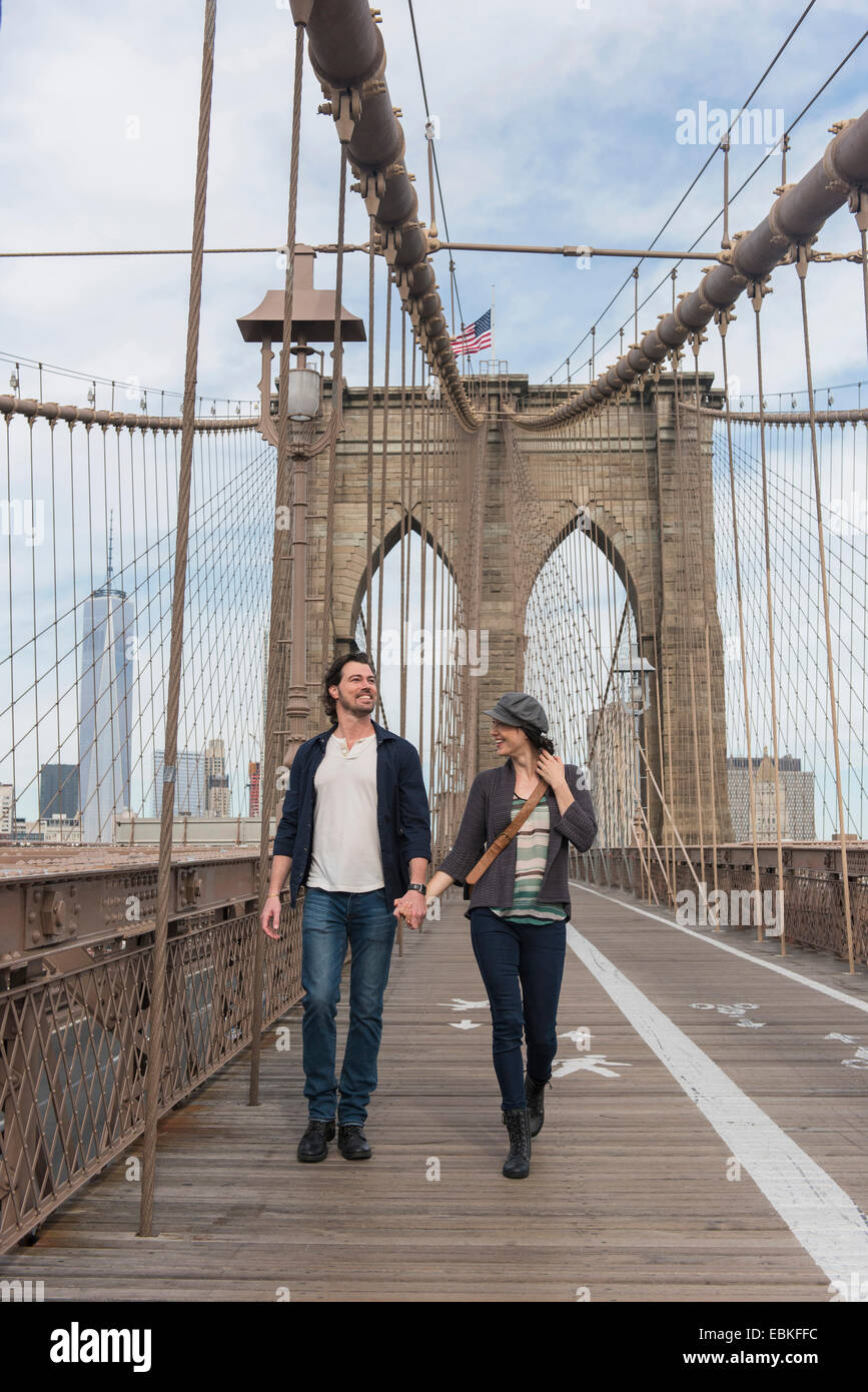 Stati Uniti d'America, nello Stato di New York, New York, Brooklyn, giovane tenendo le mani e camminando sul Ponte di Brooklyn Foto Stock