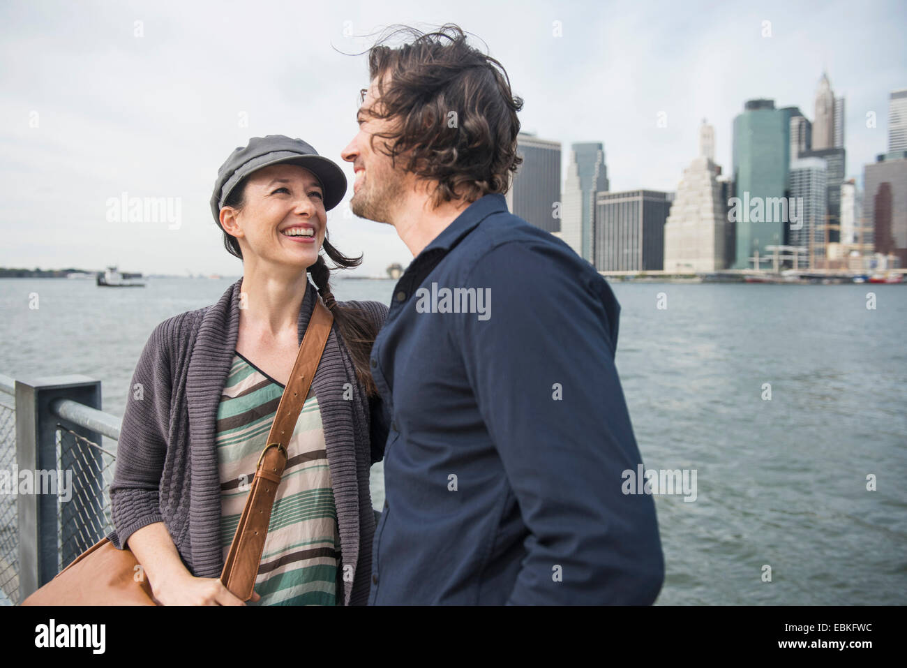 Stati Uniti d'America, nello Stato di New York, New York, Brooklyn, felice coppia in piedi contro lo skyline della città Foto Stock