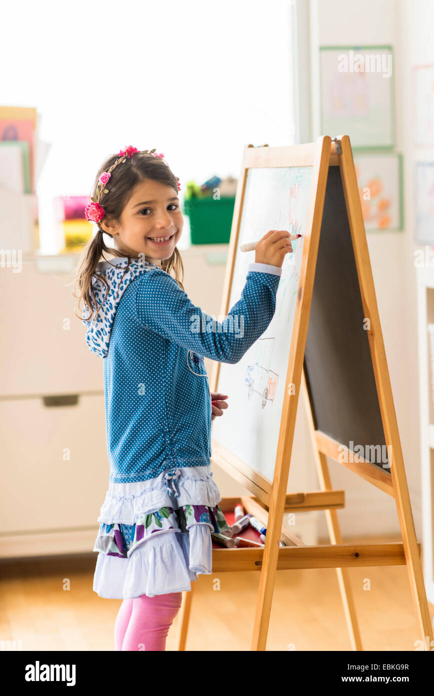 Ritratto di ragazza (6-7) scrivendo a bordo in aula Foto Stock