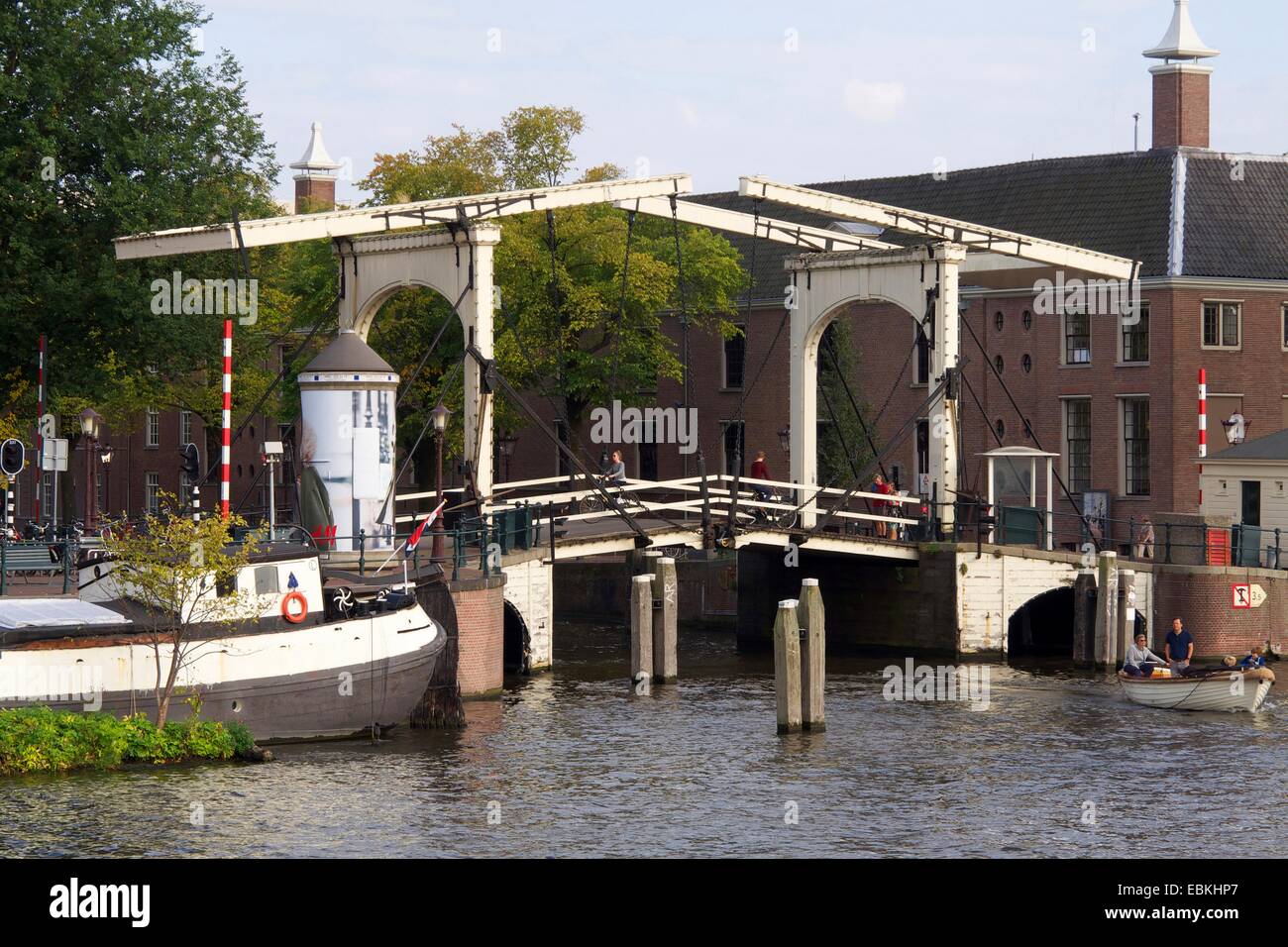 Ponte a sbalzo in legno che attraversa il fiume Amstel ad Amsterdam, che mostra l'architettura olandese e la serena vita fluviale. Paesi Bassi Foto Stock