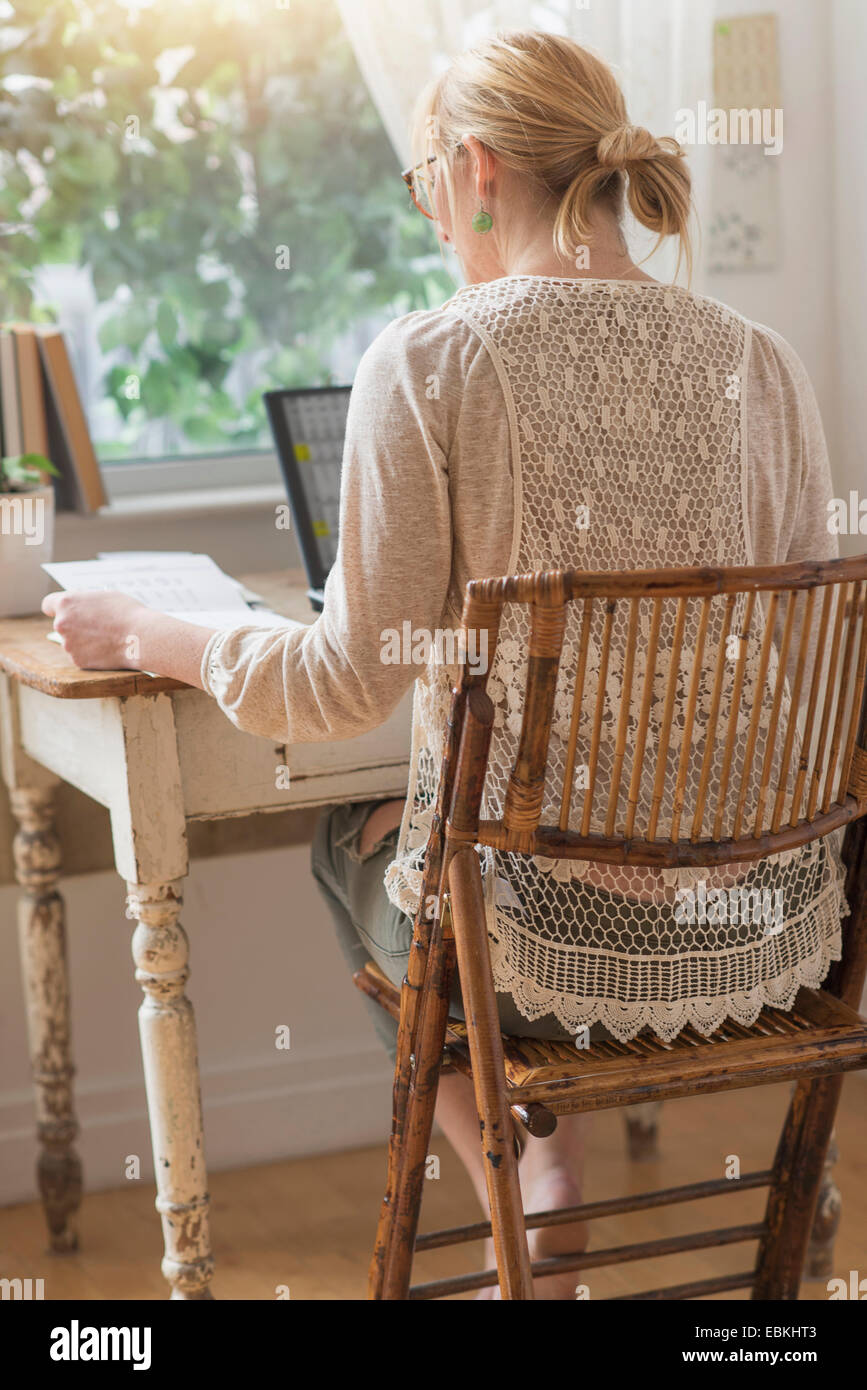 Vista posteriore della donna che lavorano con il computer portatile Foto Stock