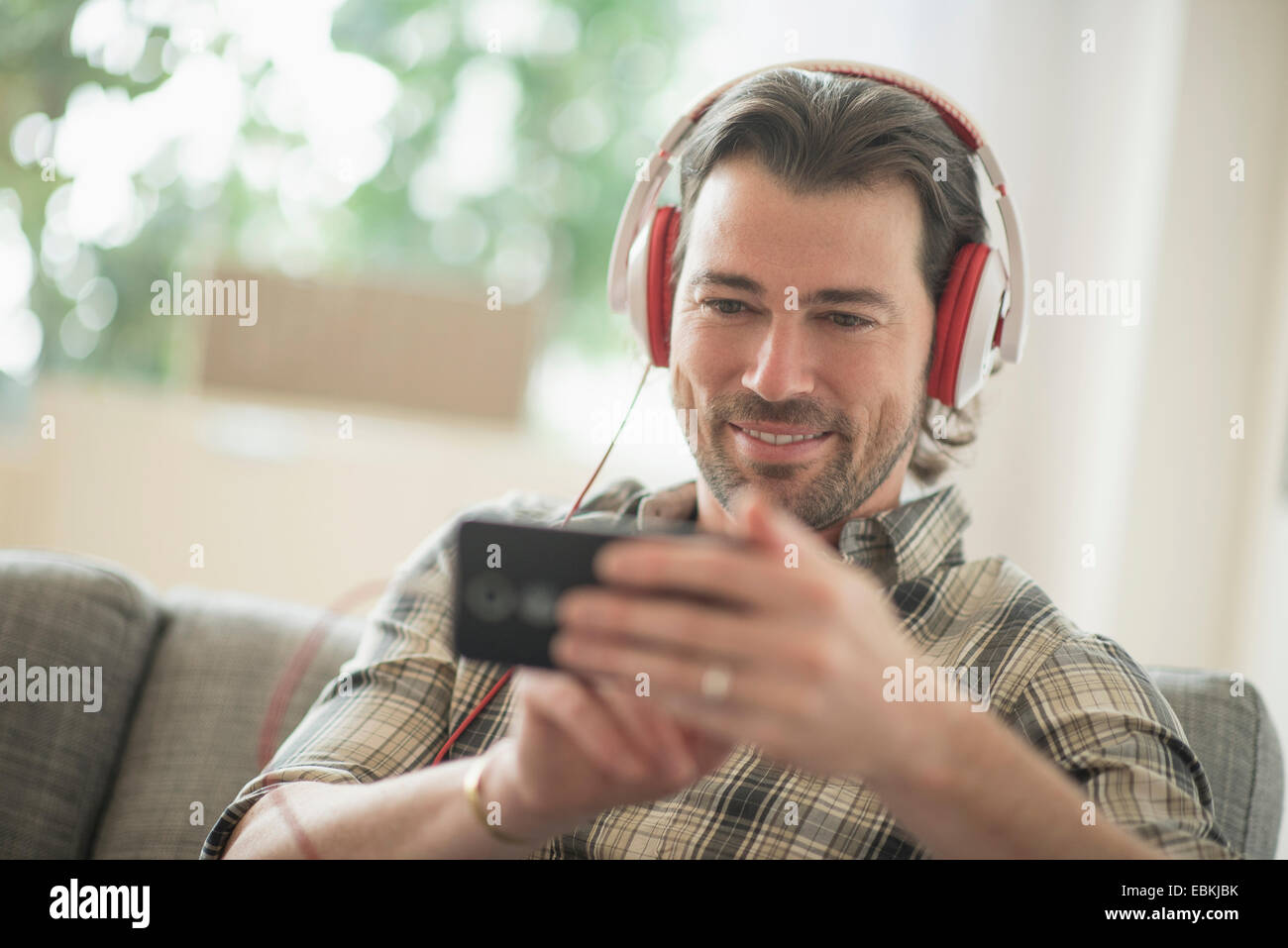 Uomo sorridente ascolto di musica Foto Stock