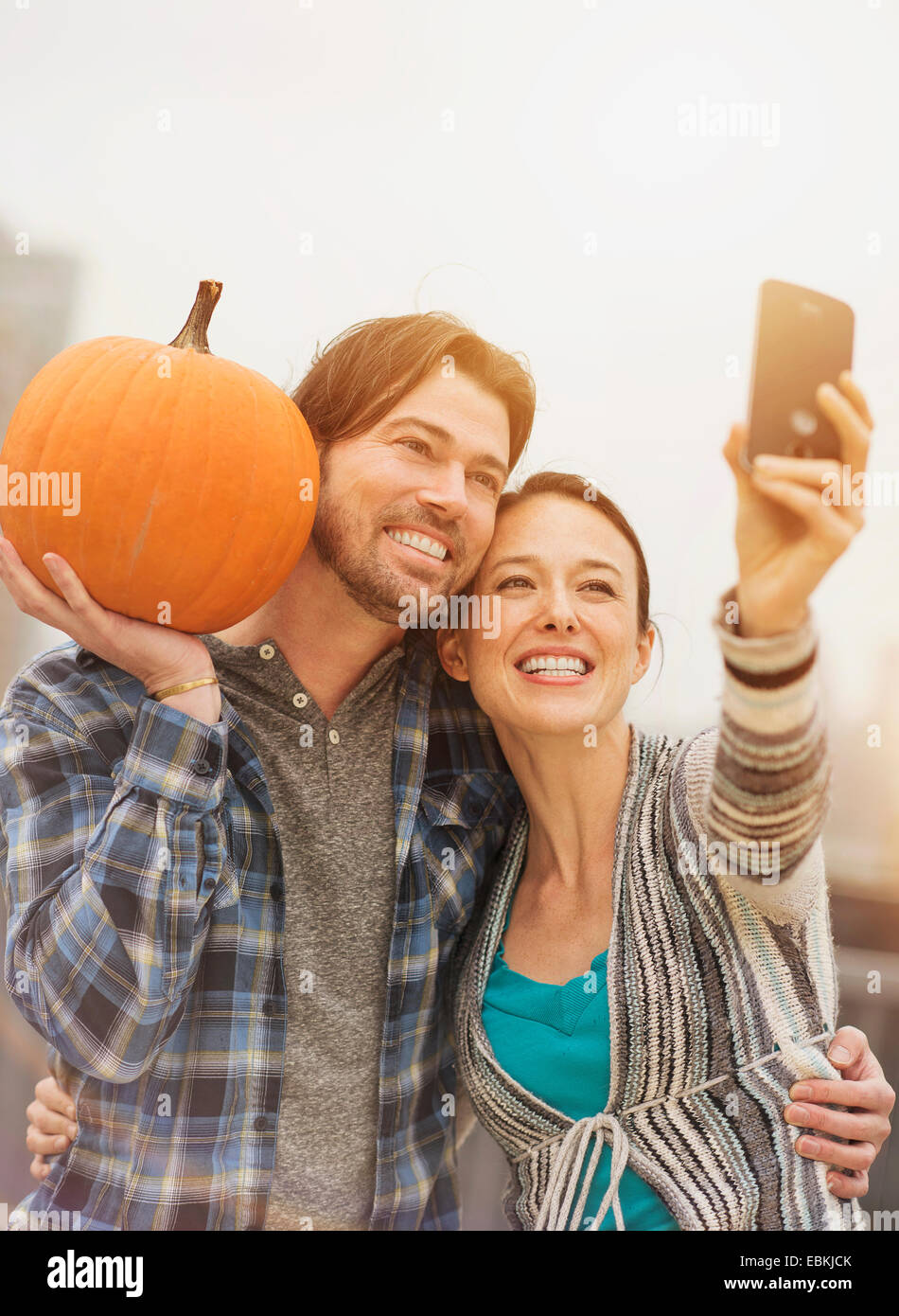Giovane tenendo selfie con telefono cellulare, uomo con la zucca Foto Stock