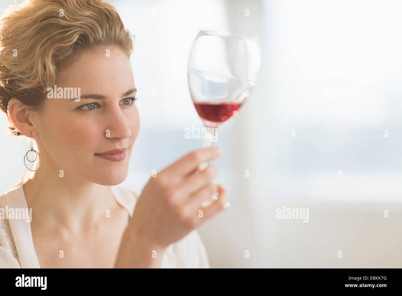 Giovane donna esame di vino rosso Foto Stock