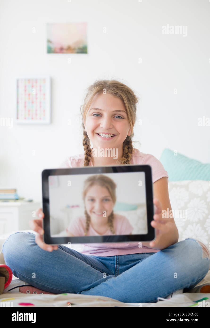 La ragazza (12-13) azienda tablet con selfie Foto Stock