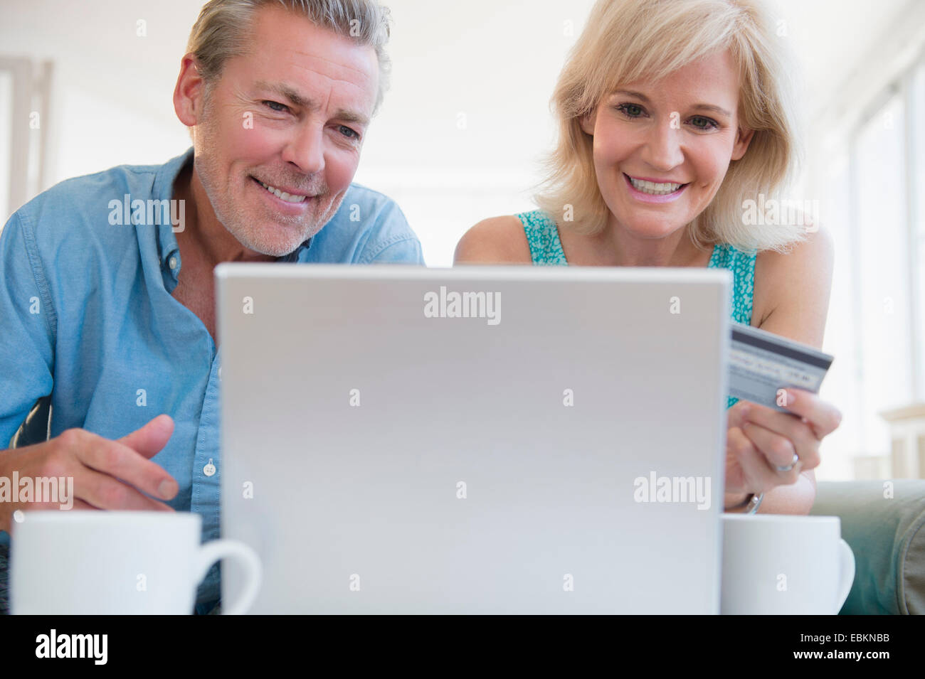 Ritratto di giovane utilizzando laptop, con carta di credito in vista Foto Stock