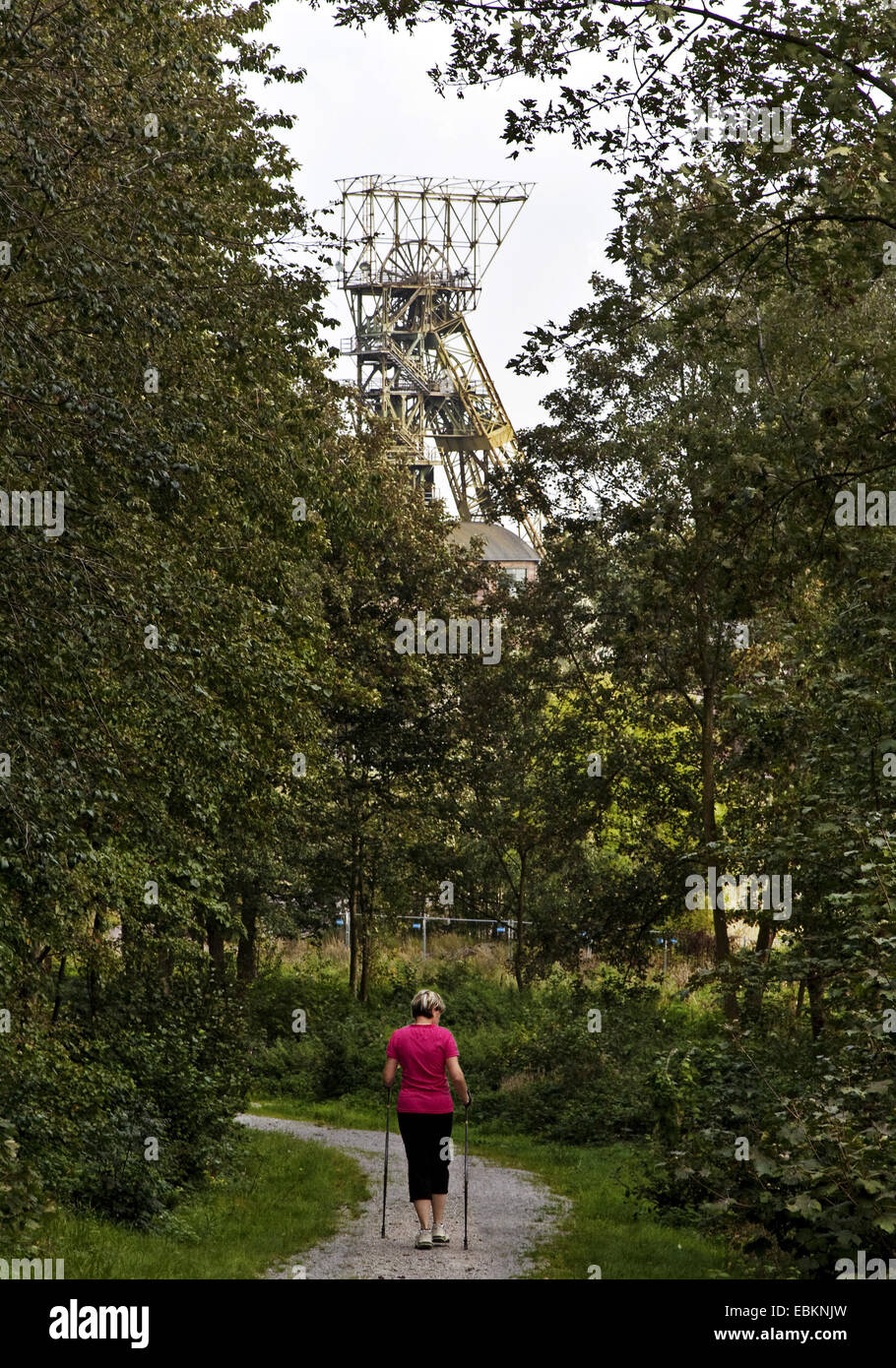 Donna facendo Nordic Walking su ex miniera di carbone Ewald, pit telaio in background, in Germania, in Renania settentrionale-Vestfalia, la zona della Ruhr, Oer-Erkenschwick Foto Stock