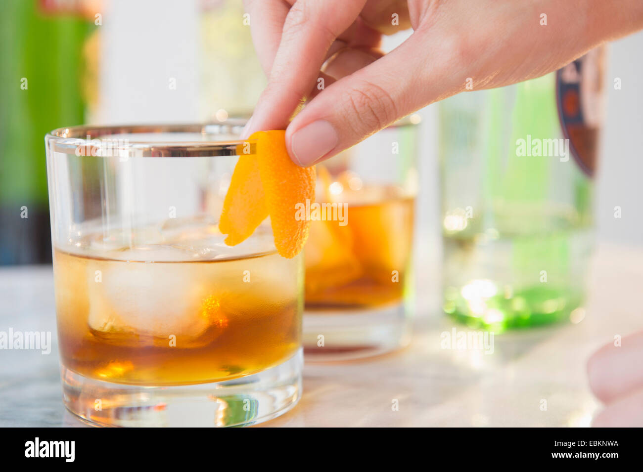 Close-up shot di barman della decorazione a mano bicchiere da cocktail con buccia di arancia Foto Stock