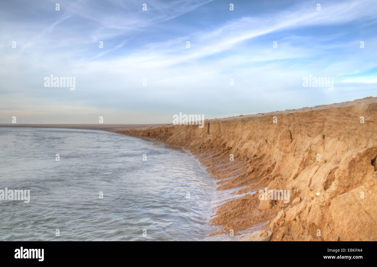 Erosione di sabbia da un flusso sulla spiaggia Foto Stock