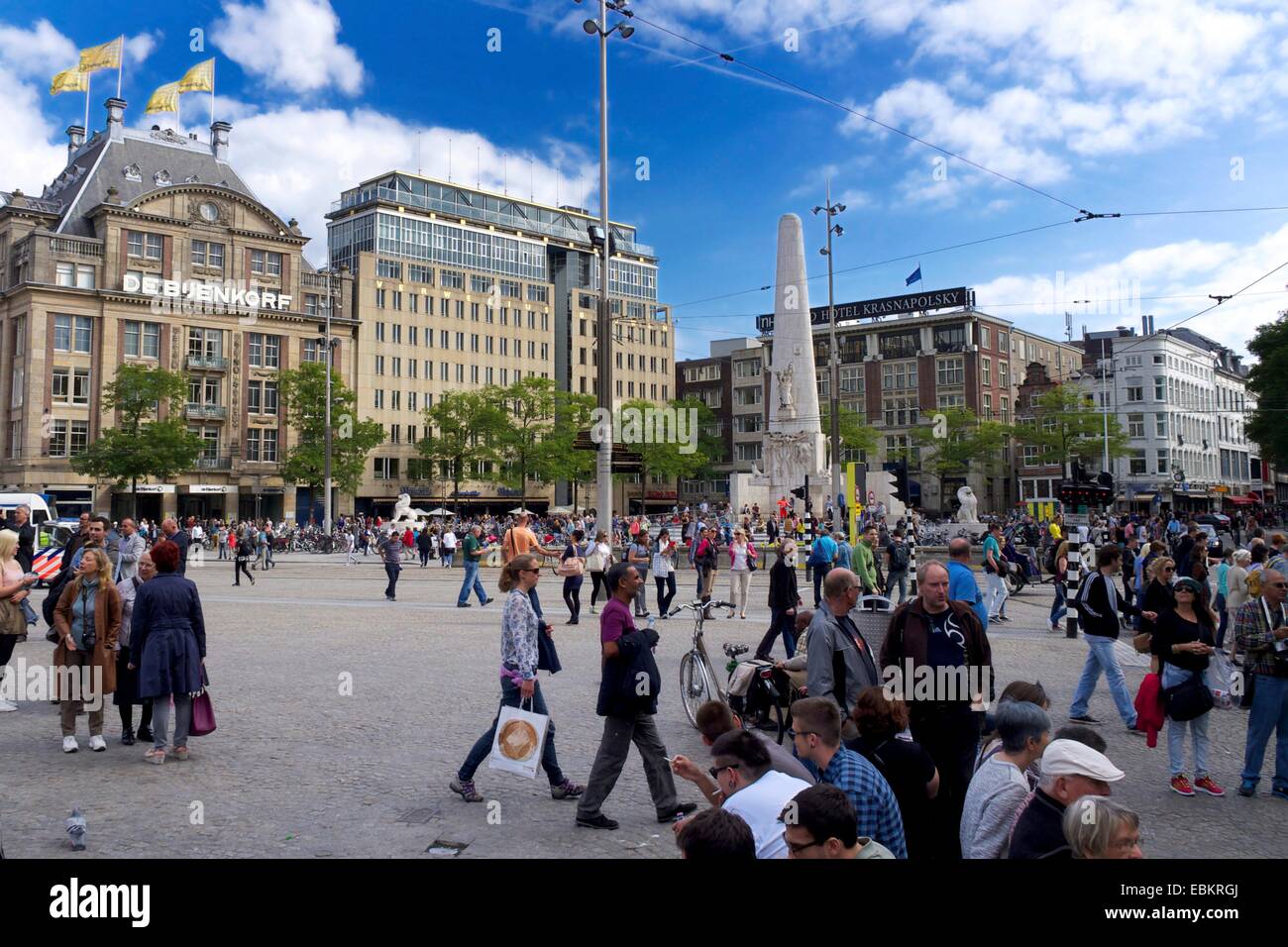 La folla si riunisce presso il Monumento Nazionale in Piazza Dam durante una giornata di sole ad Amsterdam. Paesi Bassi, Europa Foto Stock