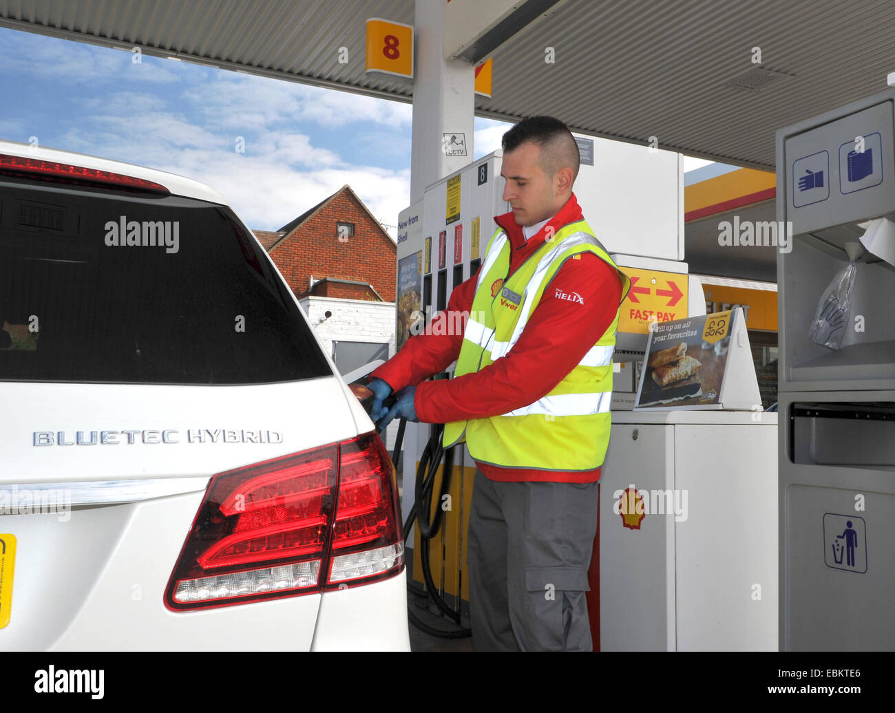 Riempimento di operatore con una vettura diesel e un guscio la stazione di benzina Foto Stock