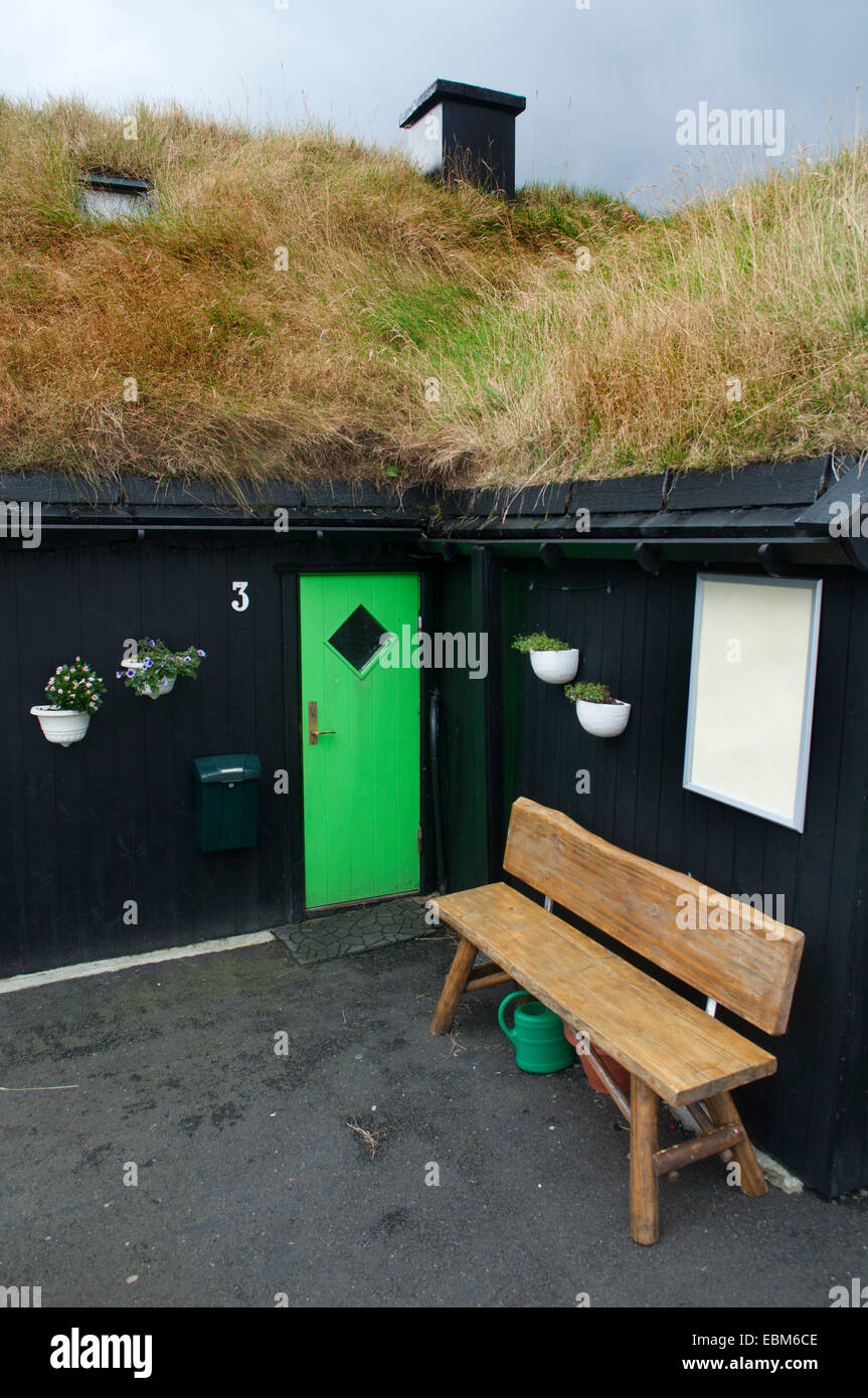 Un banco di fronte a una casa tipica con erba sul tetto, Gjógv, Esturoy isola, isole Faerøer Foto Stock