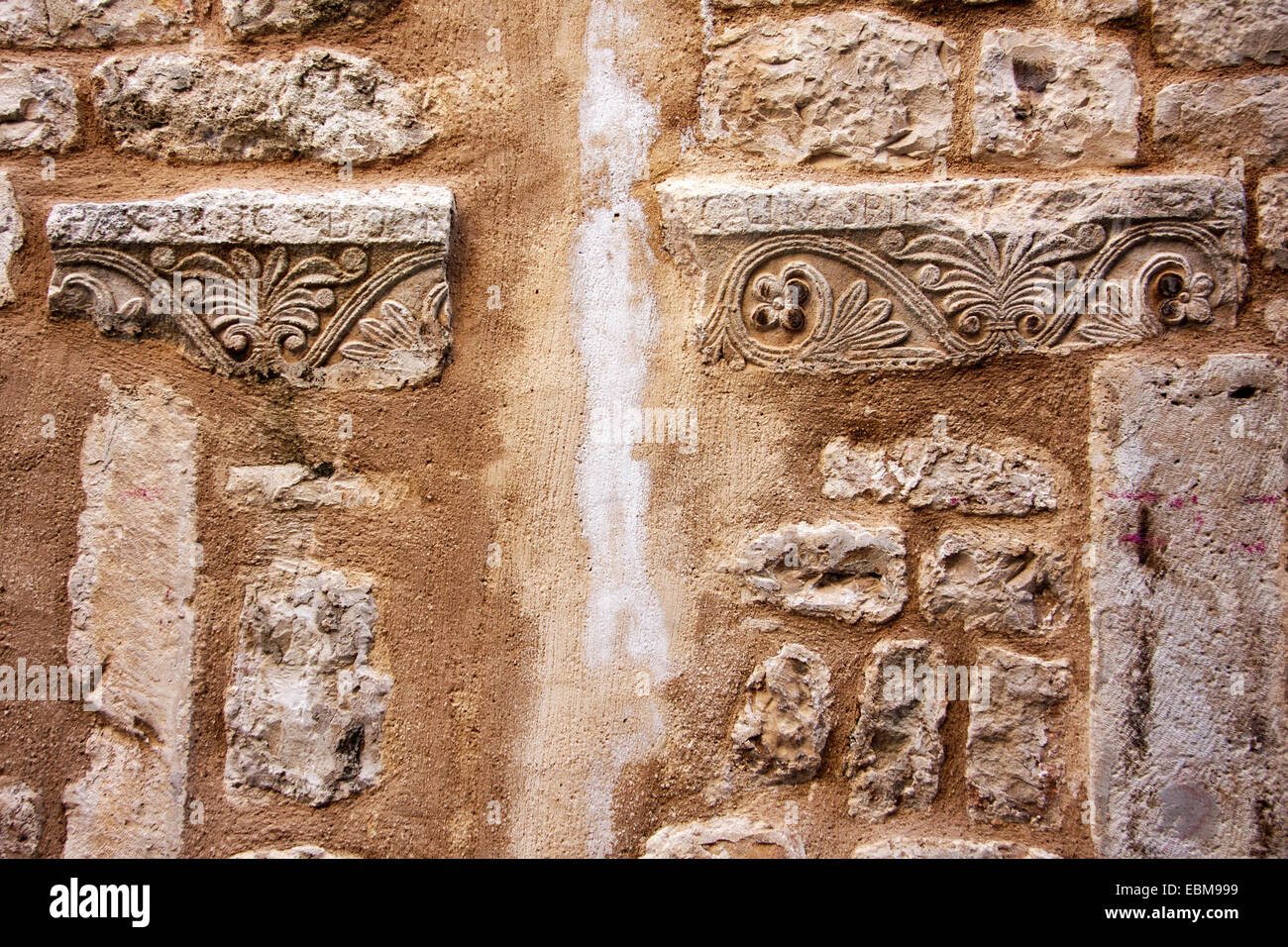 Il vecchio muro di pietra con implementata ornamenti antichi dettaglio Foto Stock