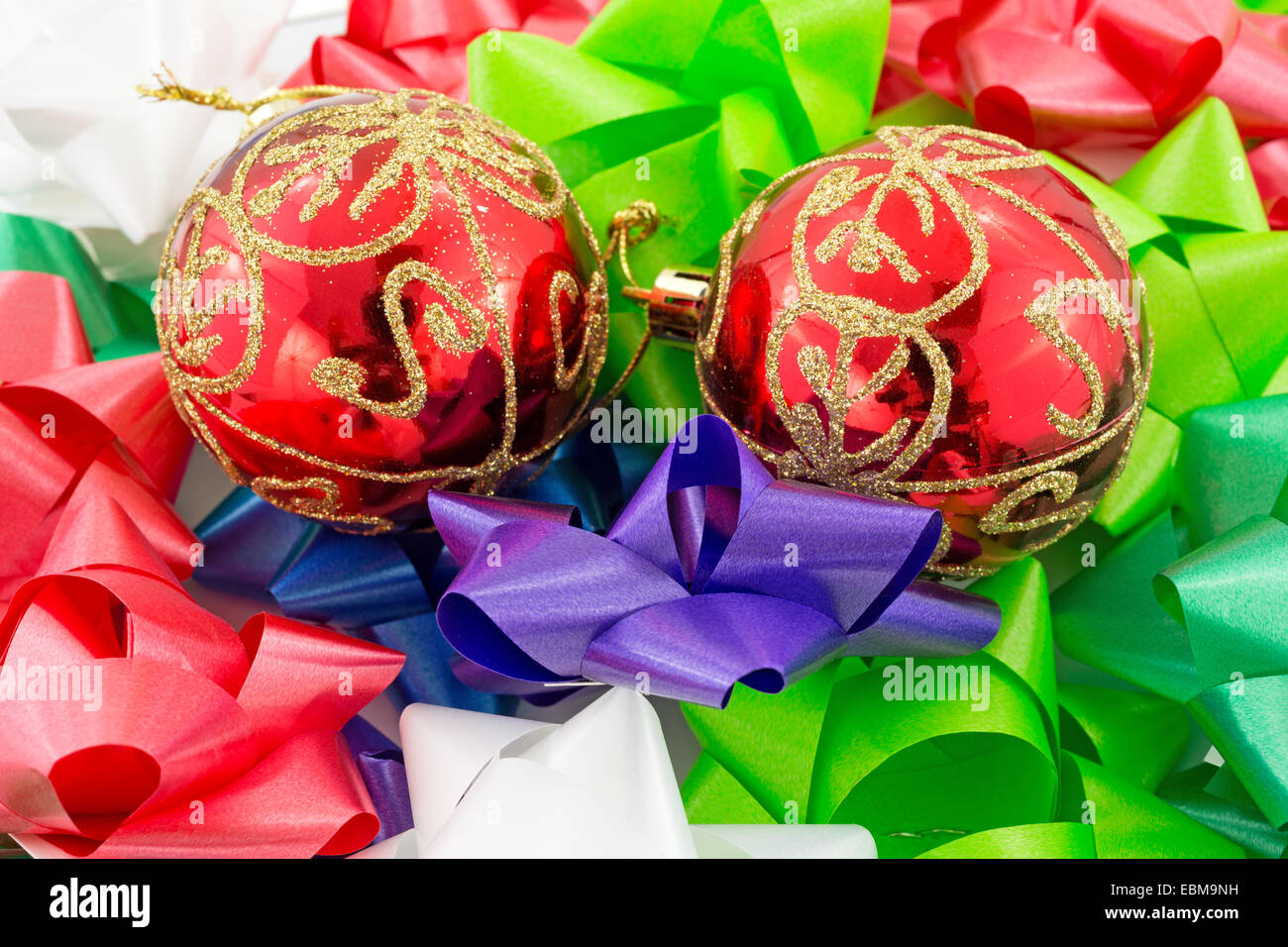 Due luminosi rosso ornamenti Natale regalo sulla cima di prua. Foto Stock