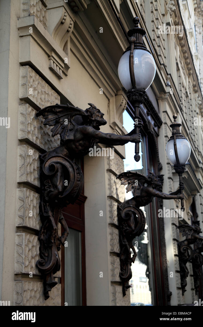 Immagine verticale di statue o decorazioni di creature mitiche tenendo una lampada Foto Stock