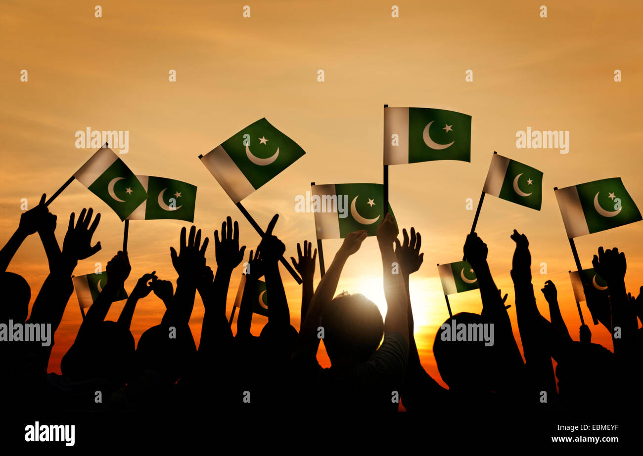 Gruppo di persone sventola Bandiera del Pakistan nel retro illuminato Foto Stock