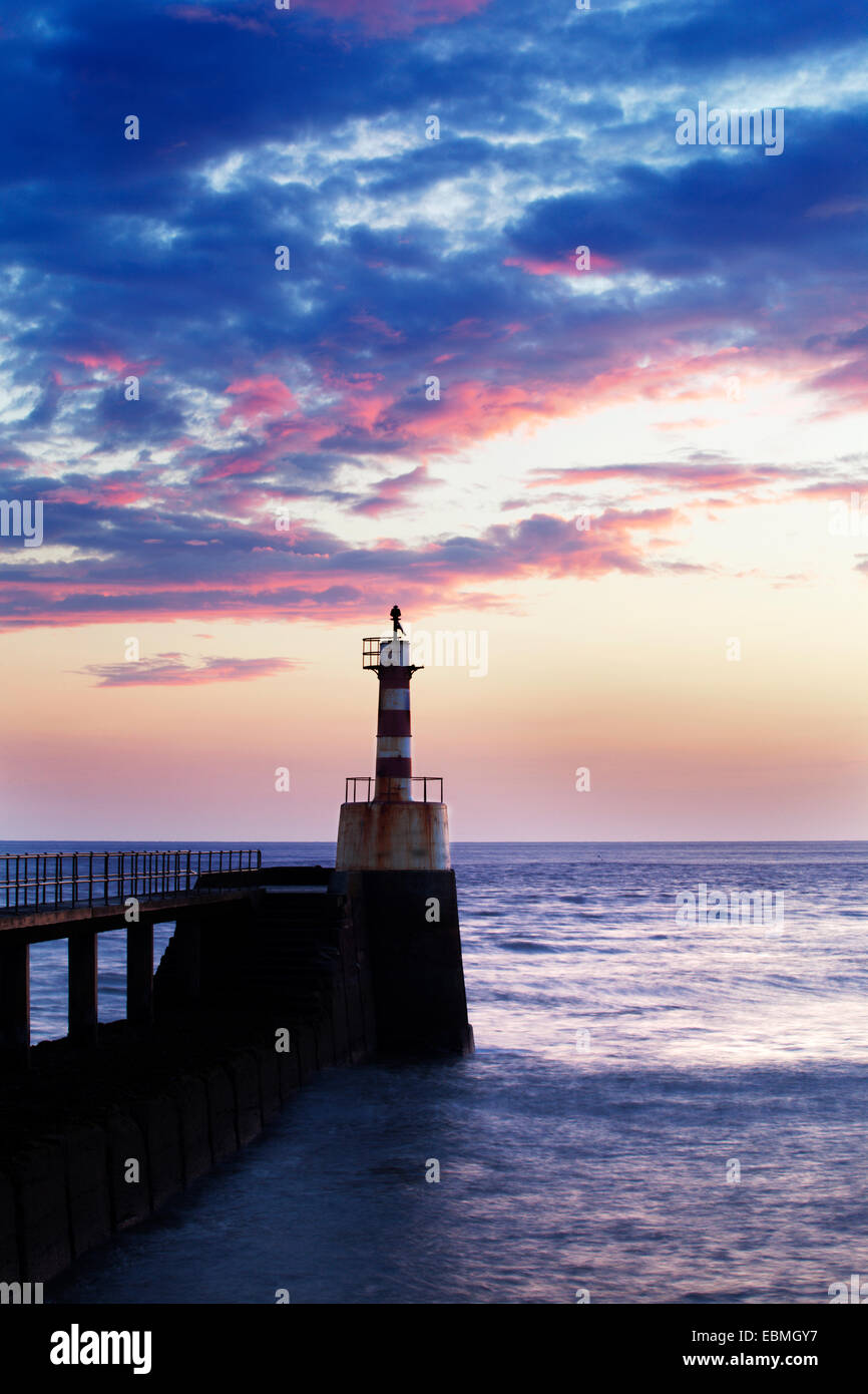 Ampio Porto luce a Sunrise camminare sul mare Northumberland Inghilterra Foto Stock