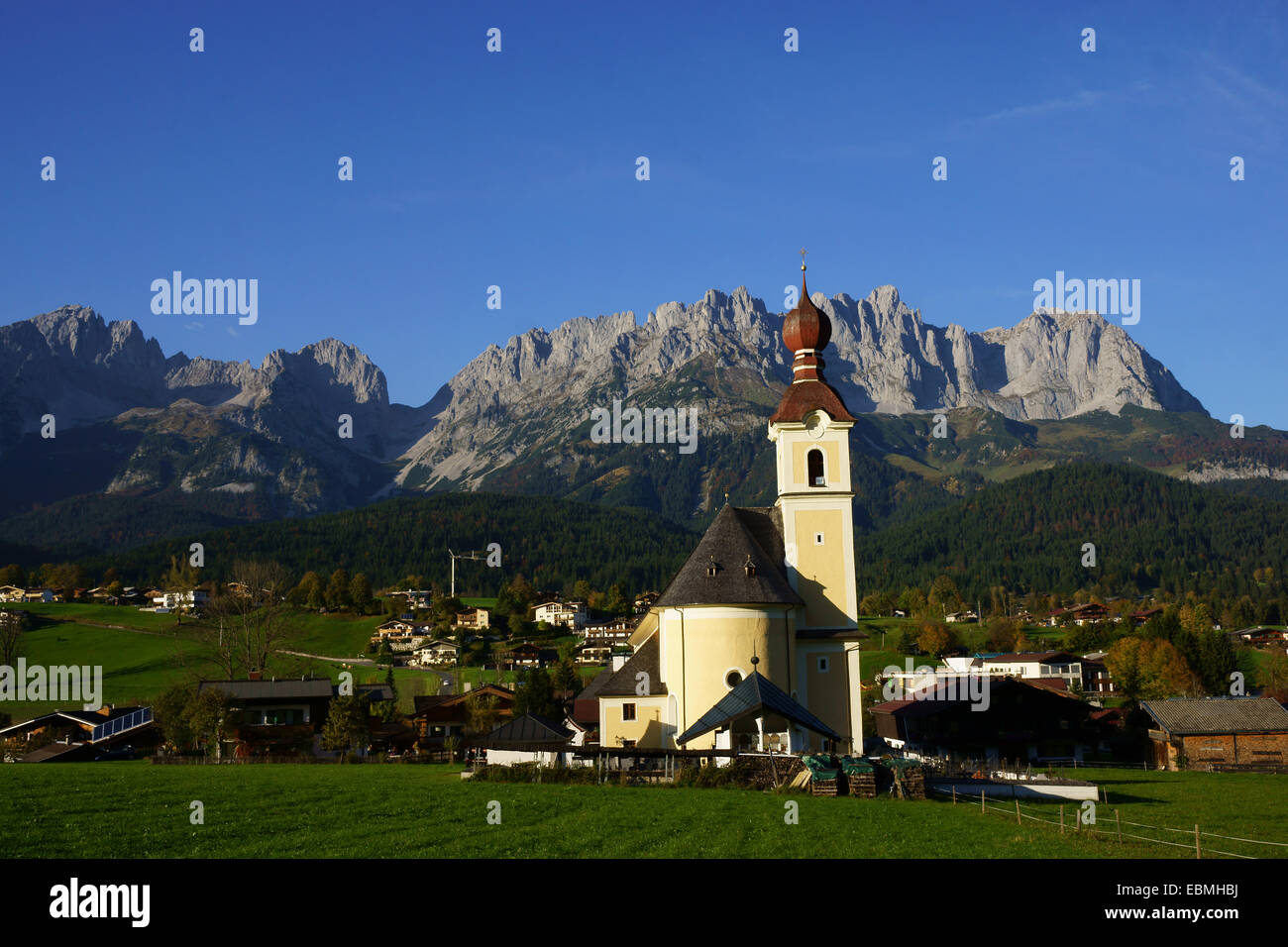 La chiesa e la città di andare, la catena montuosa di Wilder Kaiser in Tirolo, Austria Foto Stock