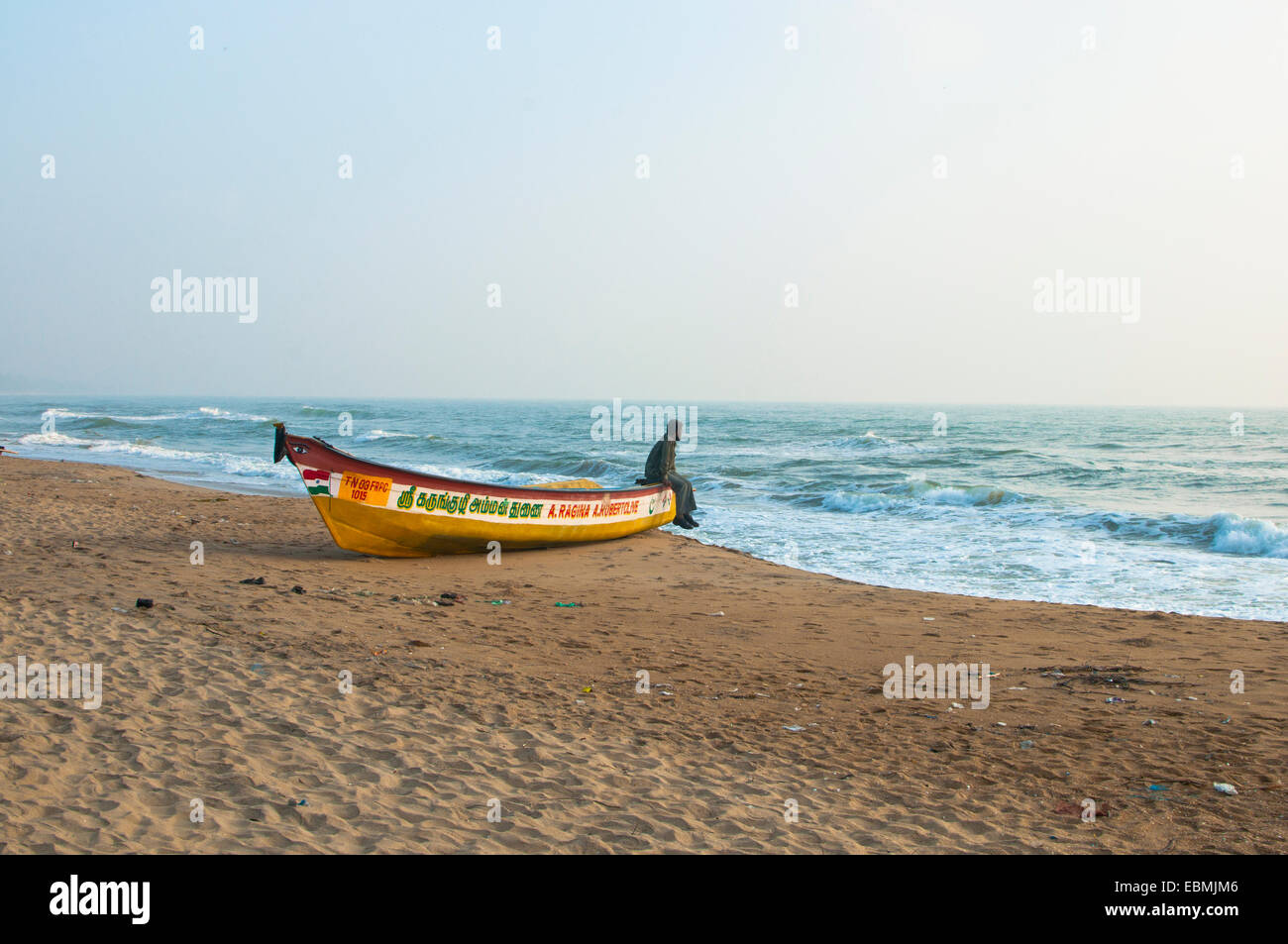 Un uomo su una barca su una spiaggia, Mamallapuram, Tamil Nadu, India Foto Stock