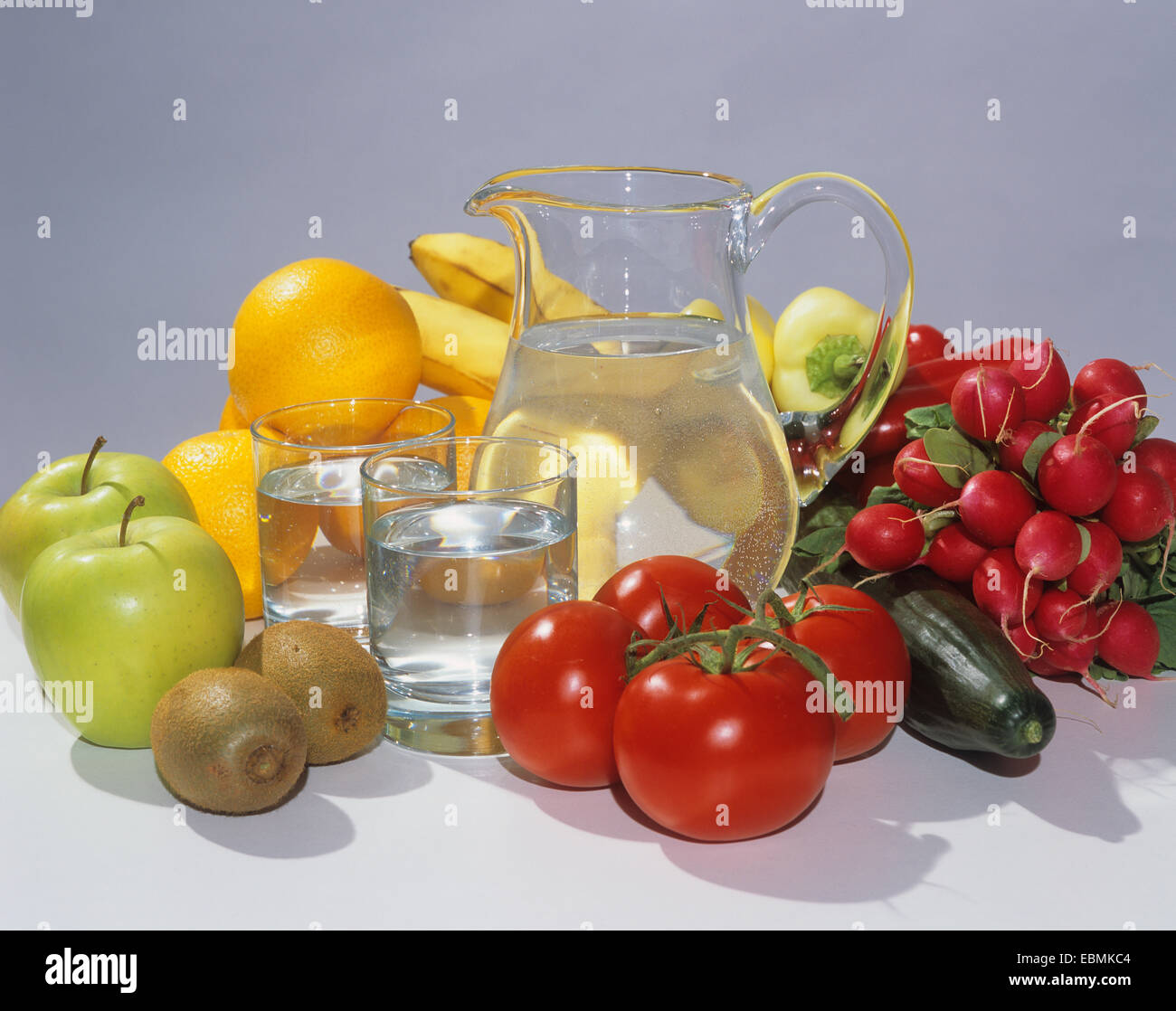 Caraffa di vetro riempito con acqua, due bicchieri, frutta e verdura Foto Stock
