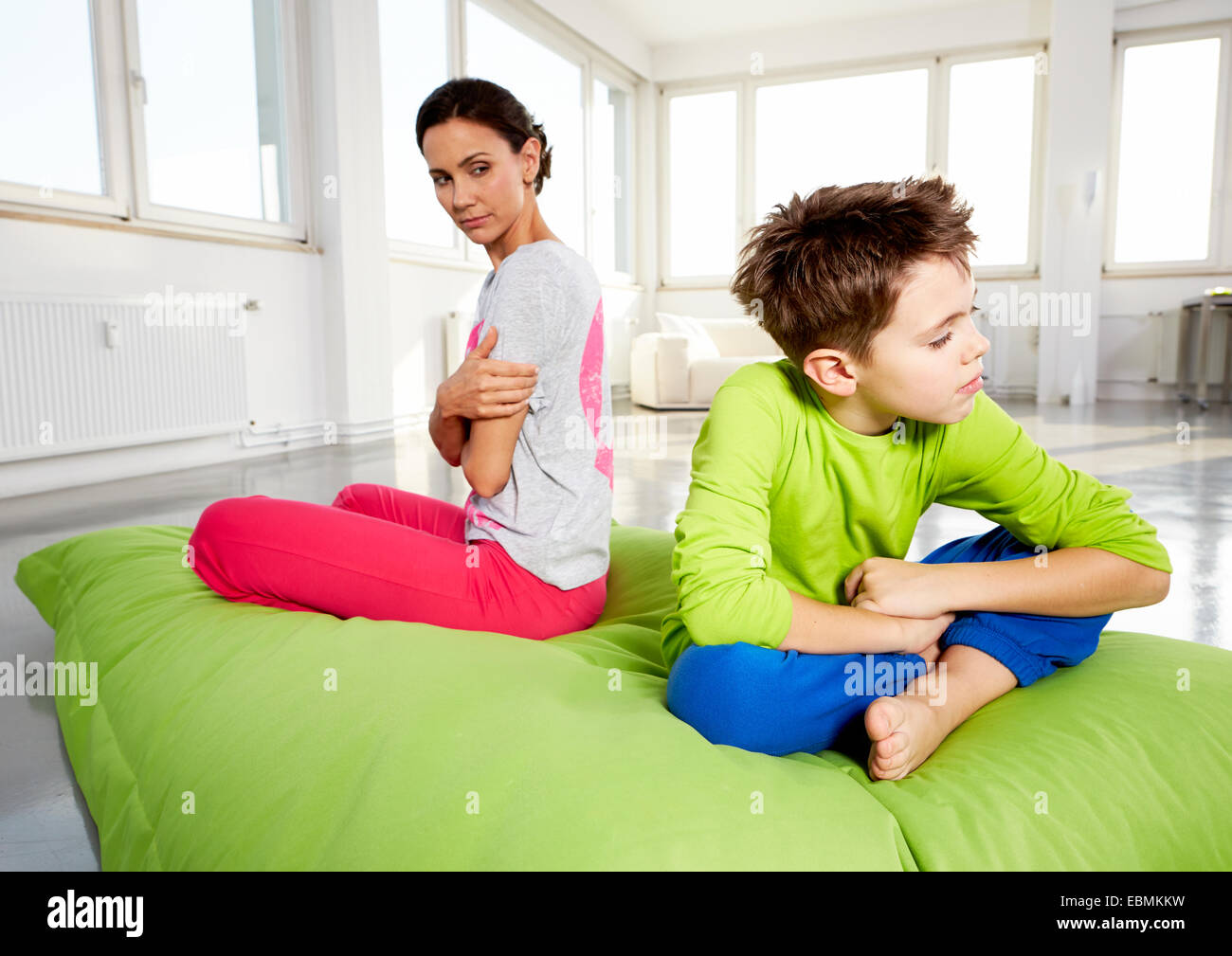 Giovane donna e figlio sconvolto, seduto su un beanbag in un loft, Germania Foto Stock
