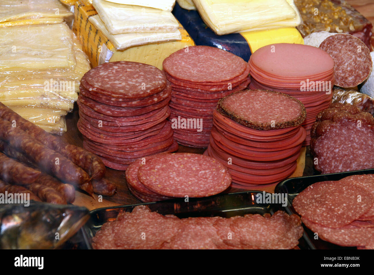 Fette di formaggio e salumi prodotti in vendita in una macelleria Foto Stock
