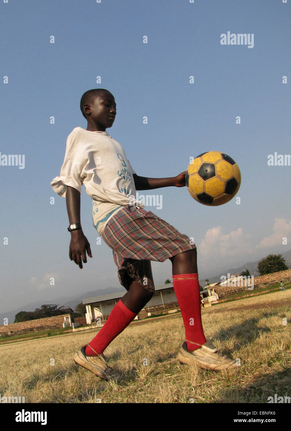 Ragazzo giocando a calcio nella città del vecchio stadio di calcio, Burundi, Bujumbura mairie, Bujumbura Foto Stock