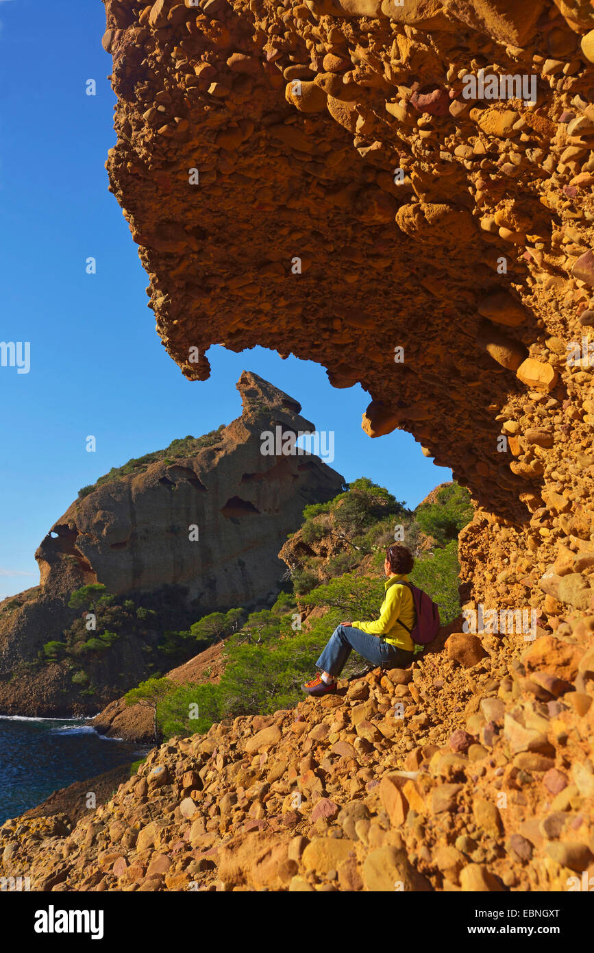 Donna enyoing la vista sotto sperone di roccia, di Calanque Figuerolles, sullo sfondo di una rupe chiamato Grand Capucin, Francia, Calanques National Park, La Ciotat Foto Stock