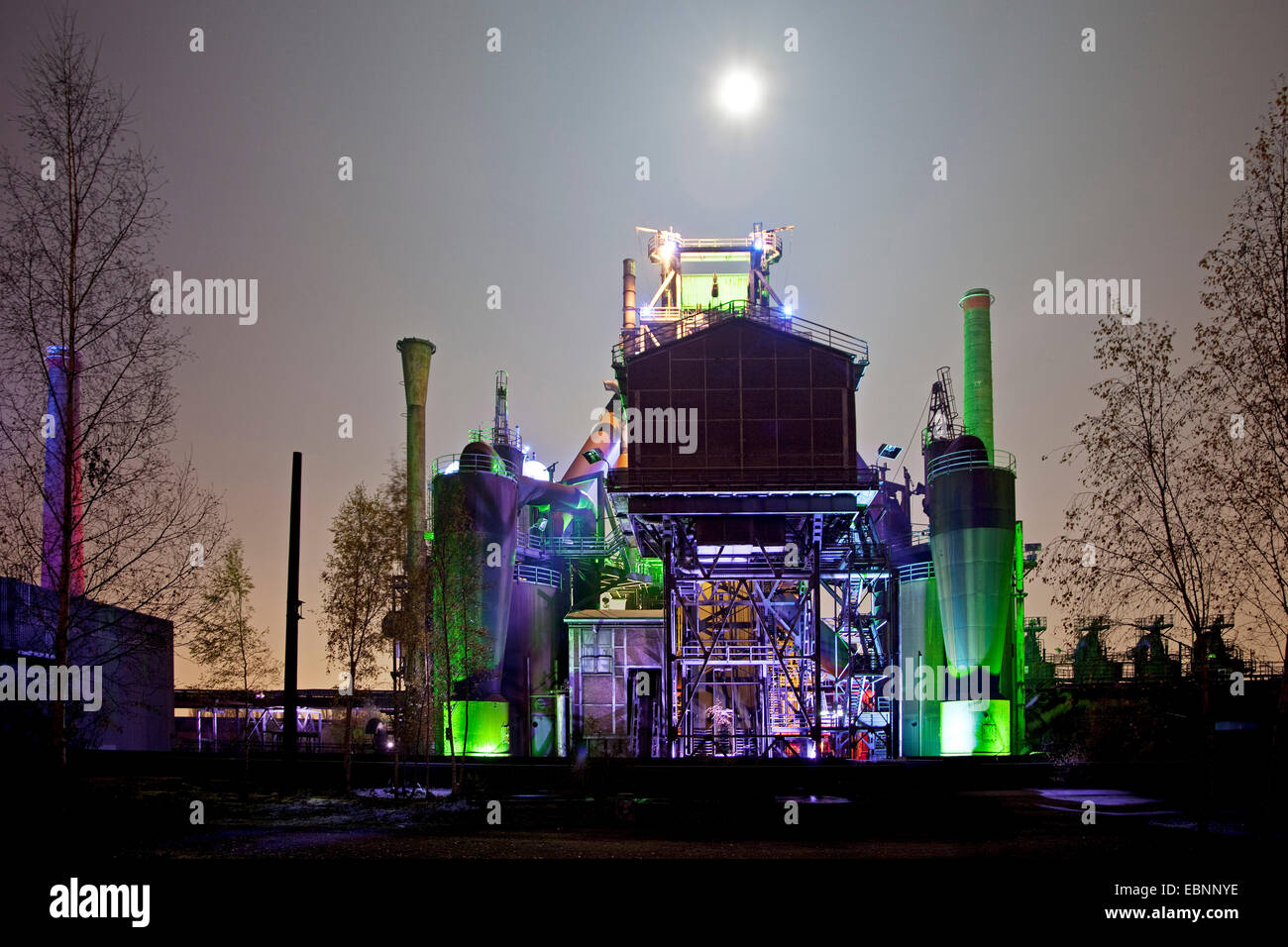 Illuminato ex mulino di acciaio e luna piena di notte, Landschaftspark Duisburg Nord, in Germania, in Renania settentrionale-Vestfalia, la zona della Ruhr, Duisburg Foto Stock