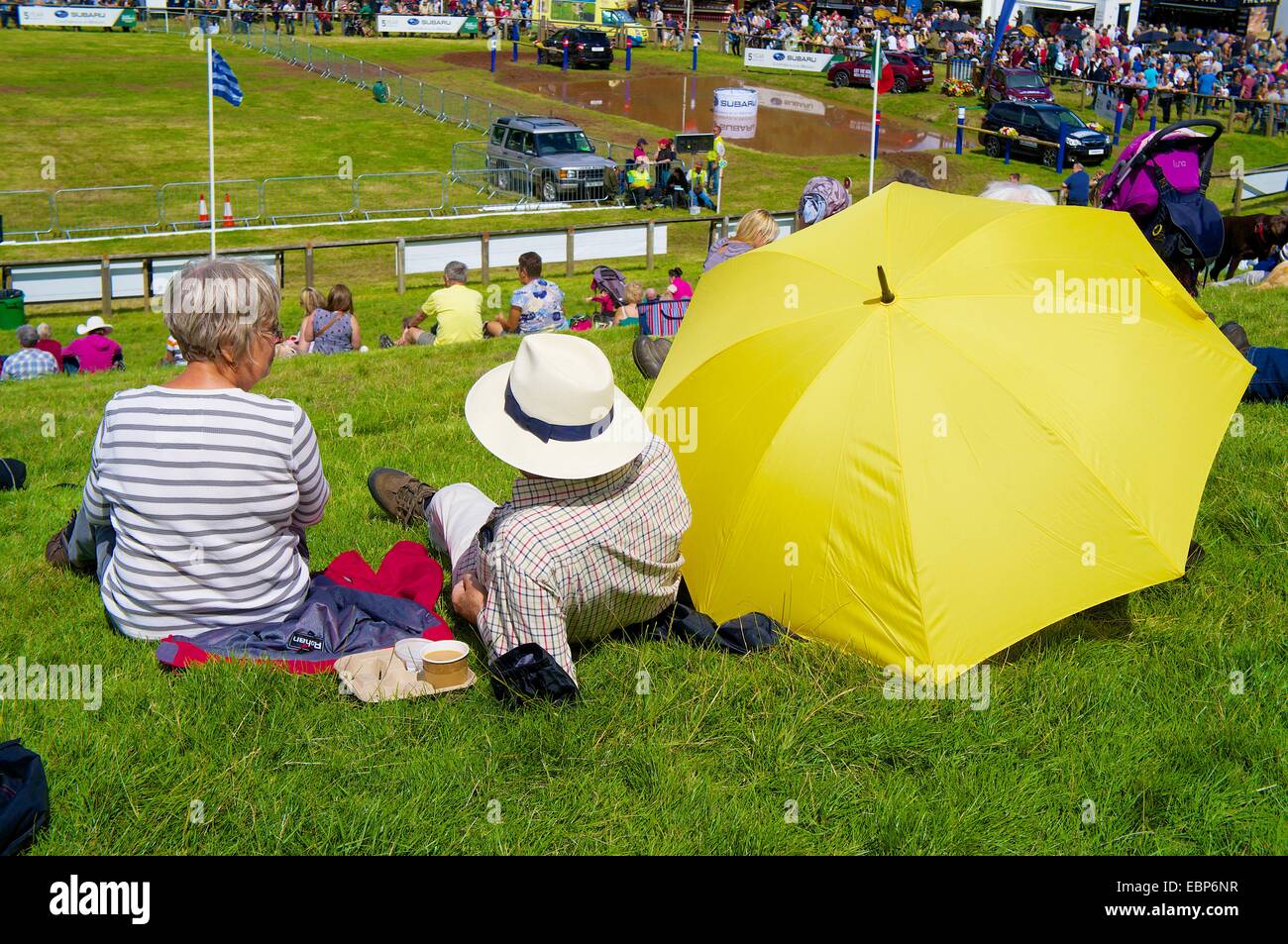 Giovane con giallo ombrellone, guardare eventi a Lowther Show, Lowther station wagon, Lowther, Penrith, Cumbria Regno Unito. Foto Stock