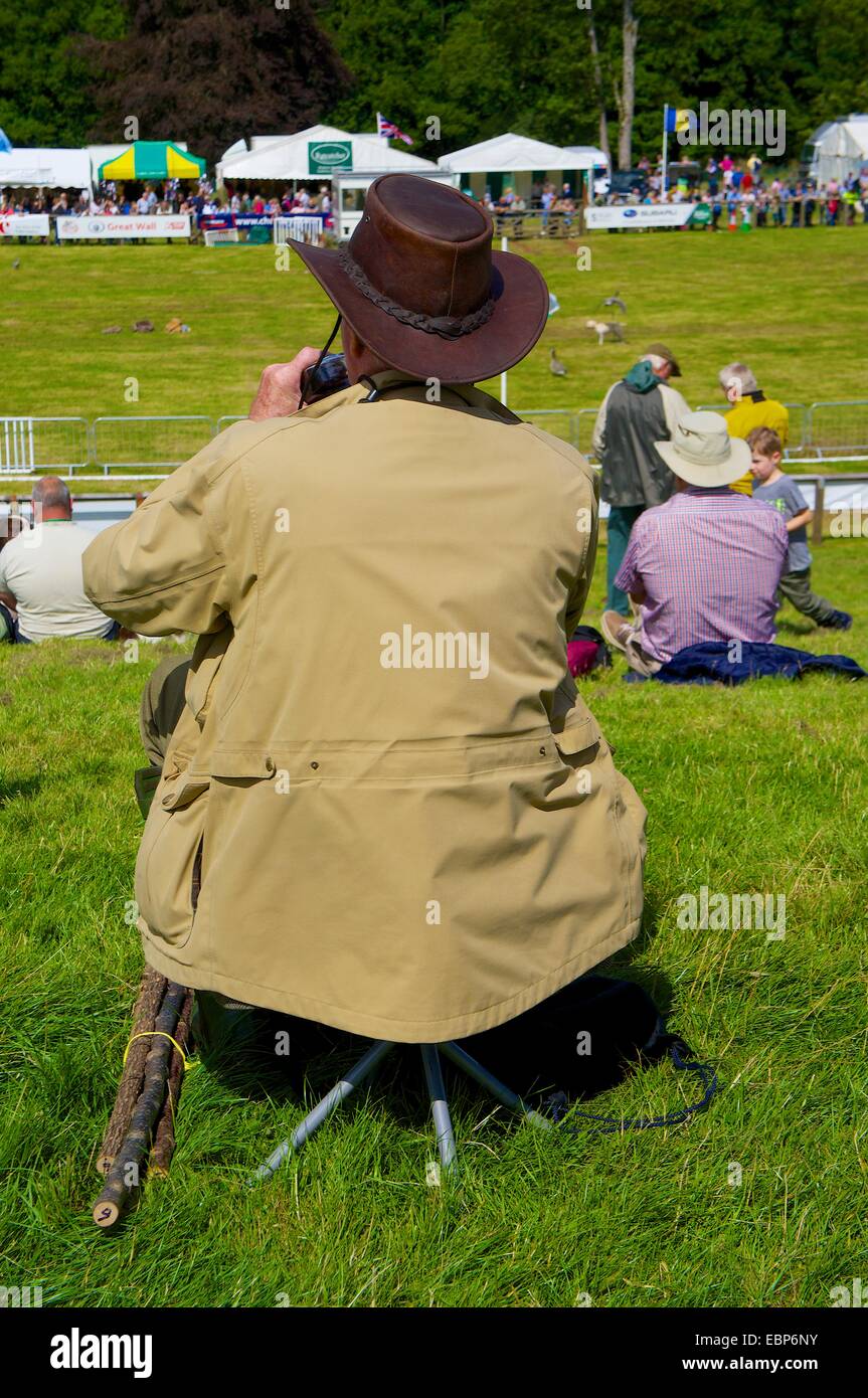 Uomo seduto su uno sgabello a guardare gli eventi a Lowther Show, Lowther station wagon, Lowther, Penrith, Cumbria. Foto Stock