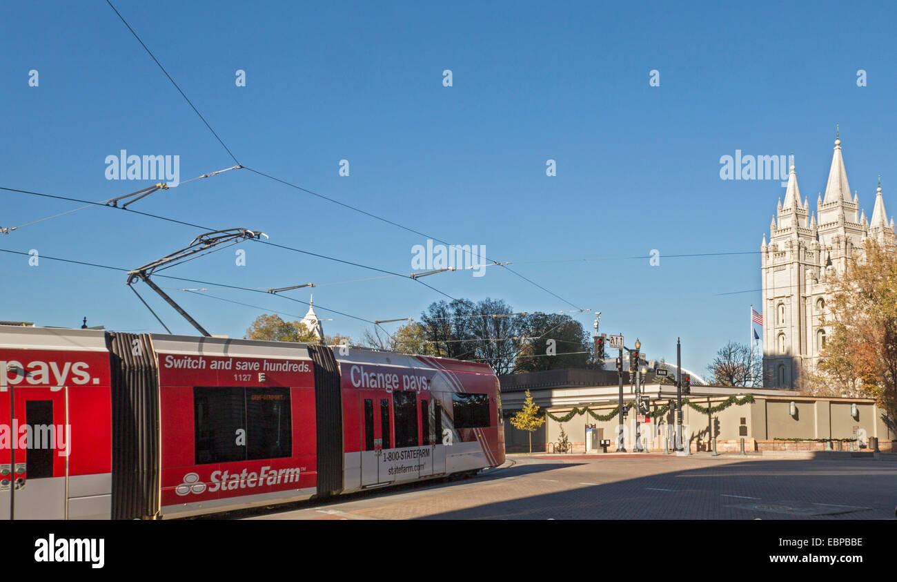 Salt Lake City, Utah - un tram di Salt Lake City TRAX del sistema ferroviario leggero passa il tempio mormone. Foto Stock