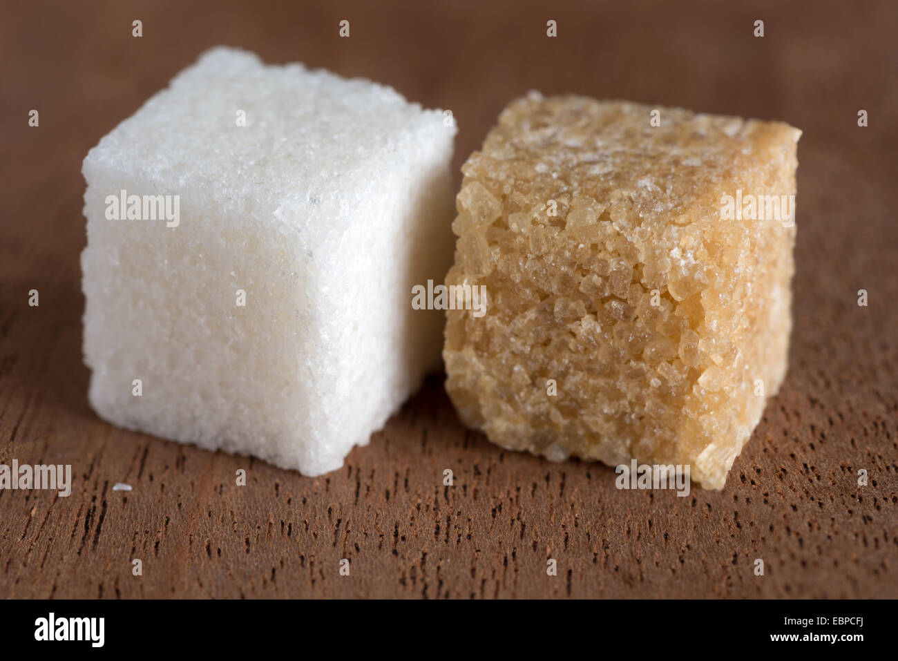 Cubetti di marrone e zucchero bianco sulla scheda di mogano Foto Stock