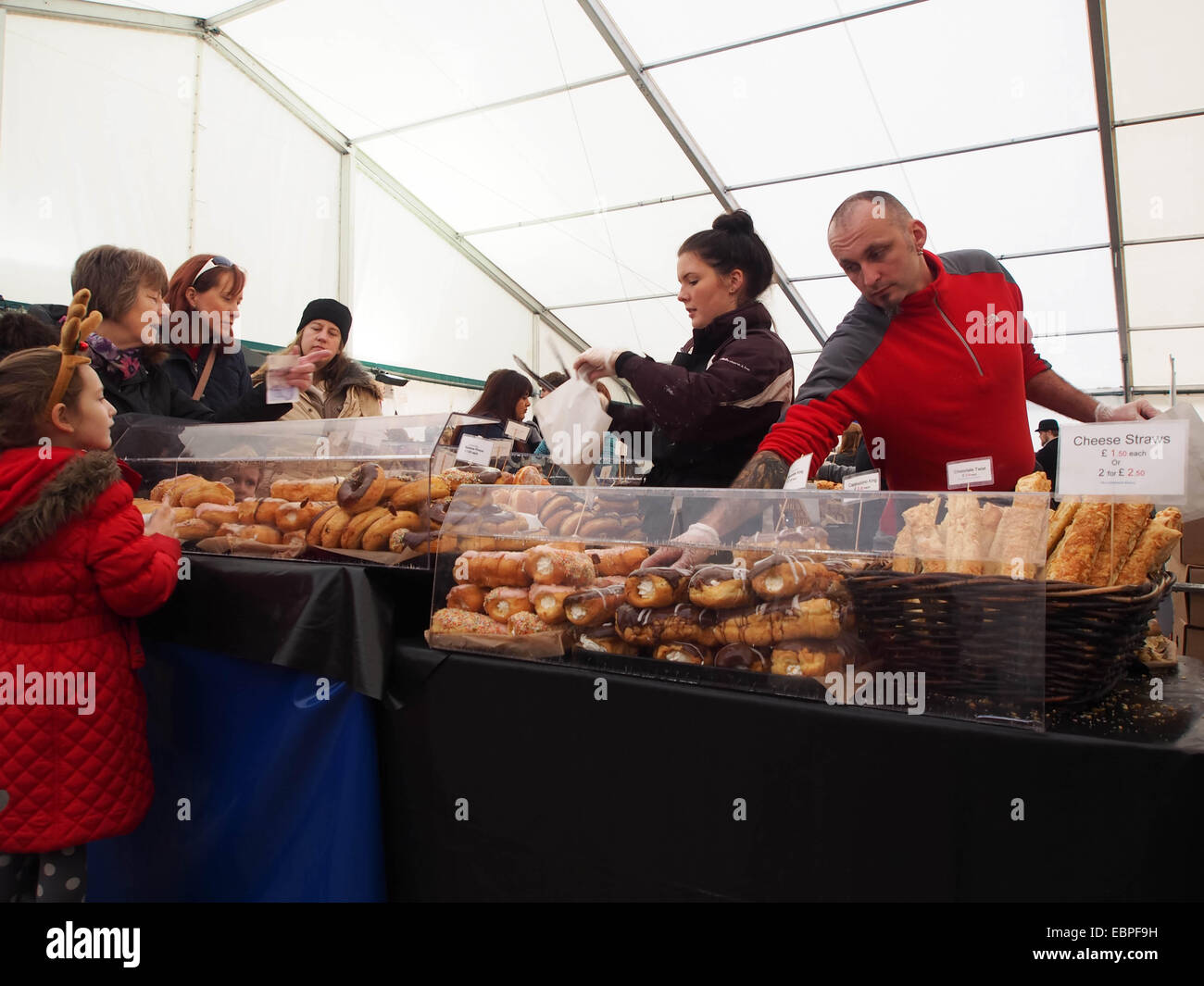 Un mercato coperto bancarella vendendo torte e pasticcini ai clienti Foto Stock