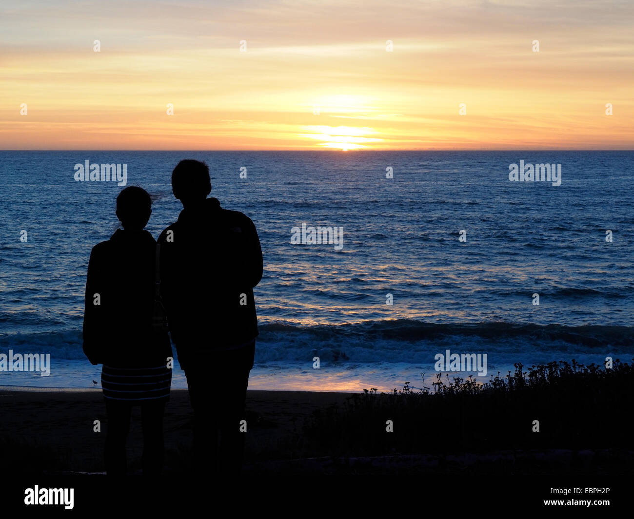 Uomo e donna hanno silhouette guardando il tramonto Foto Stock