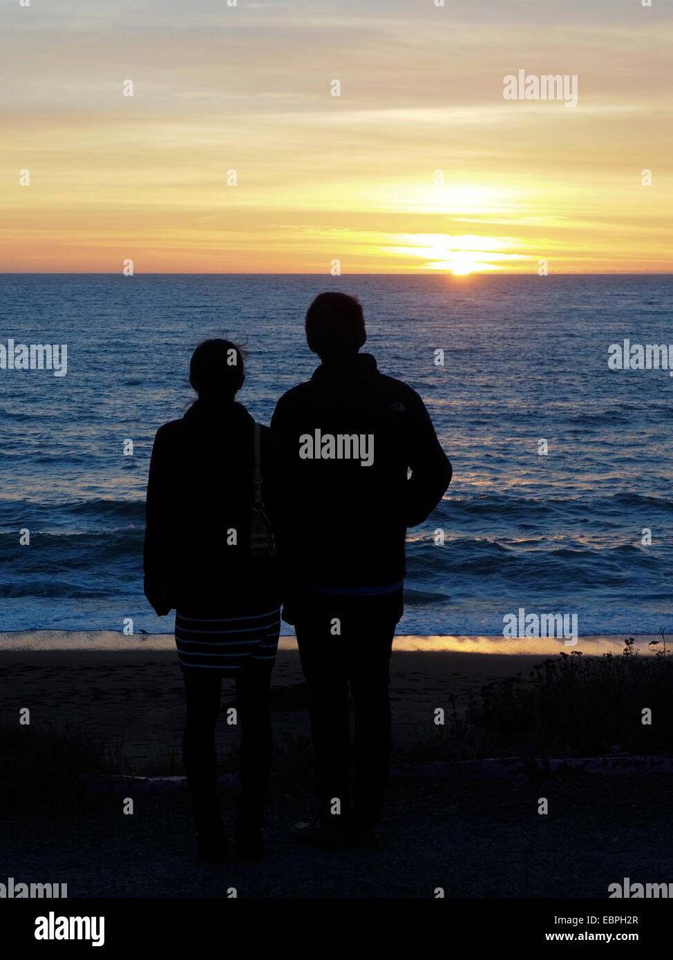 Uomo e donna hanno silhouette guardando il tramonto Foto Stock