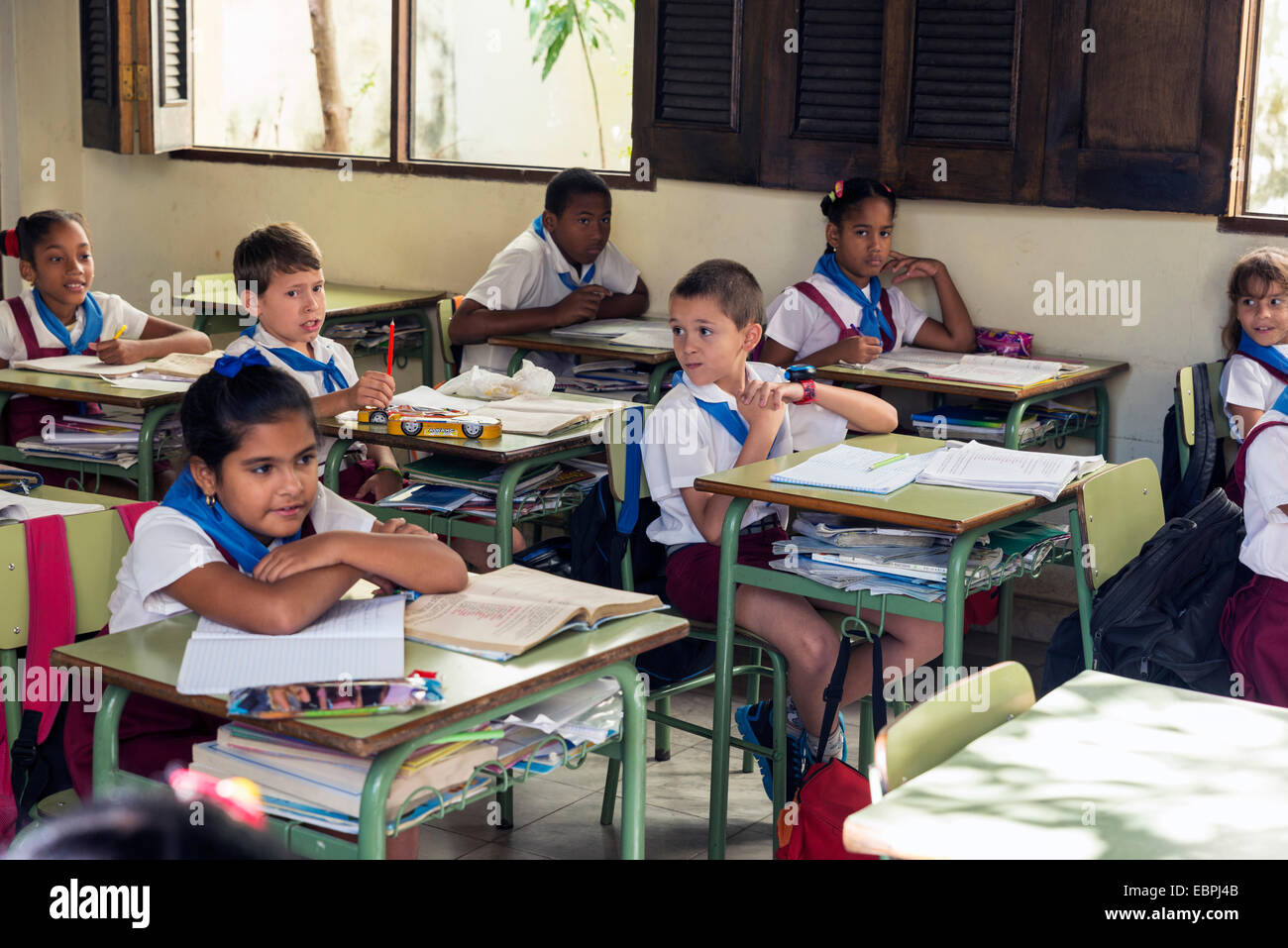 L'Avana, Cuba - 5 Maggio 2014: gruppo cubano di scolari di età elementari vestito in uniforme seduto a un mattone di Havan Foto Stock