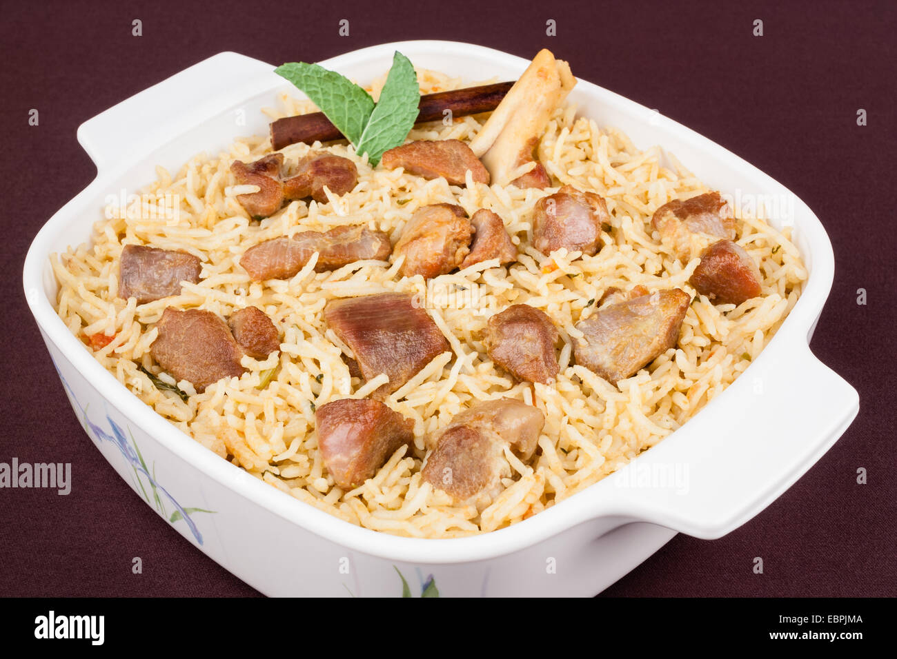 Primo piano vista dalla cima di deliziose carni di montone (agnello) biryani guarnita con con la menta e cannella. Foto Stock