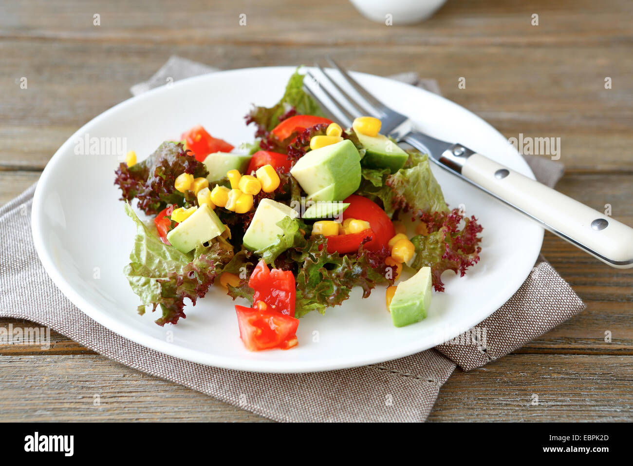 Nutriente con insalata di avocado, i pomodori e il mais su una piastra, cibo Foto Stock