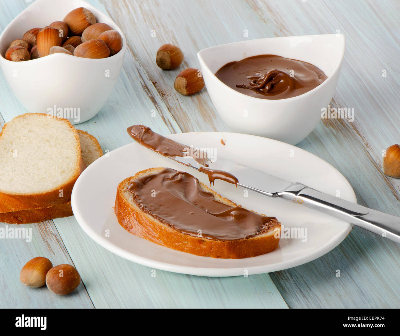 Pane e crema di cioccolato su un tavolo di legno. Messa a fuoco selettiva Foto Stock