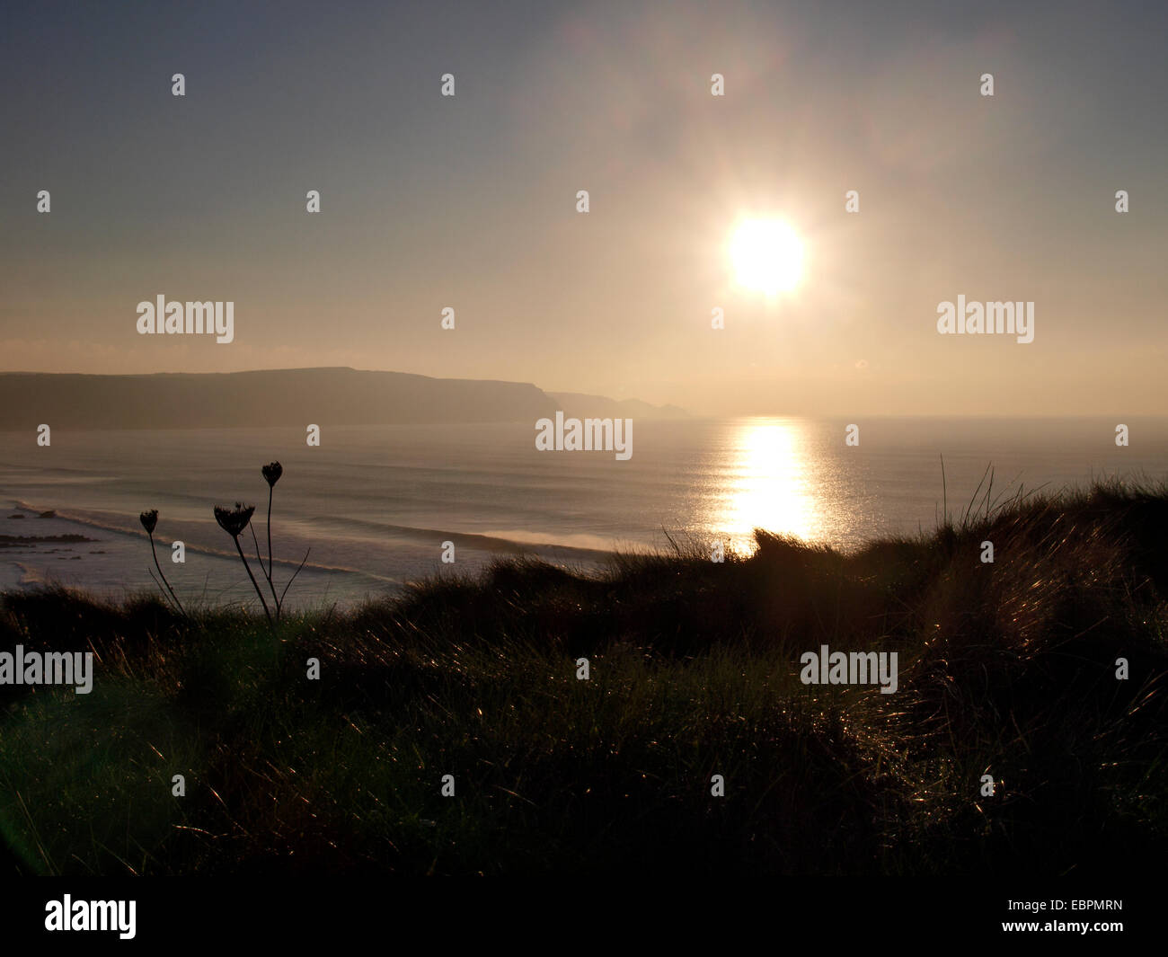 Inverno il sole oltre il Cornish Coast, Widemouth Bay, Cornwall, Regno Unito Foto Stock
