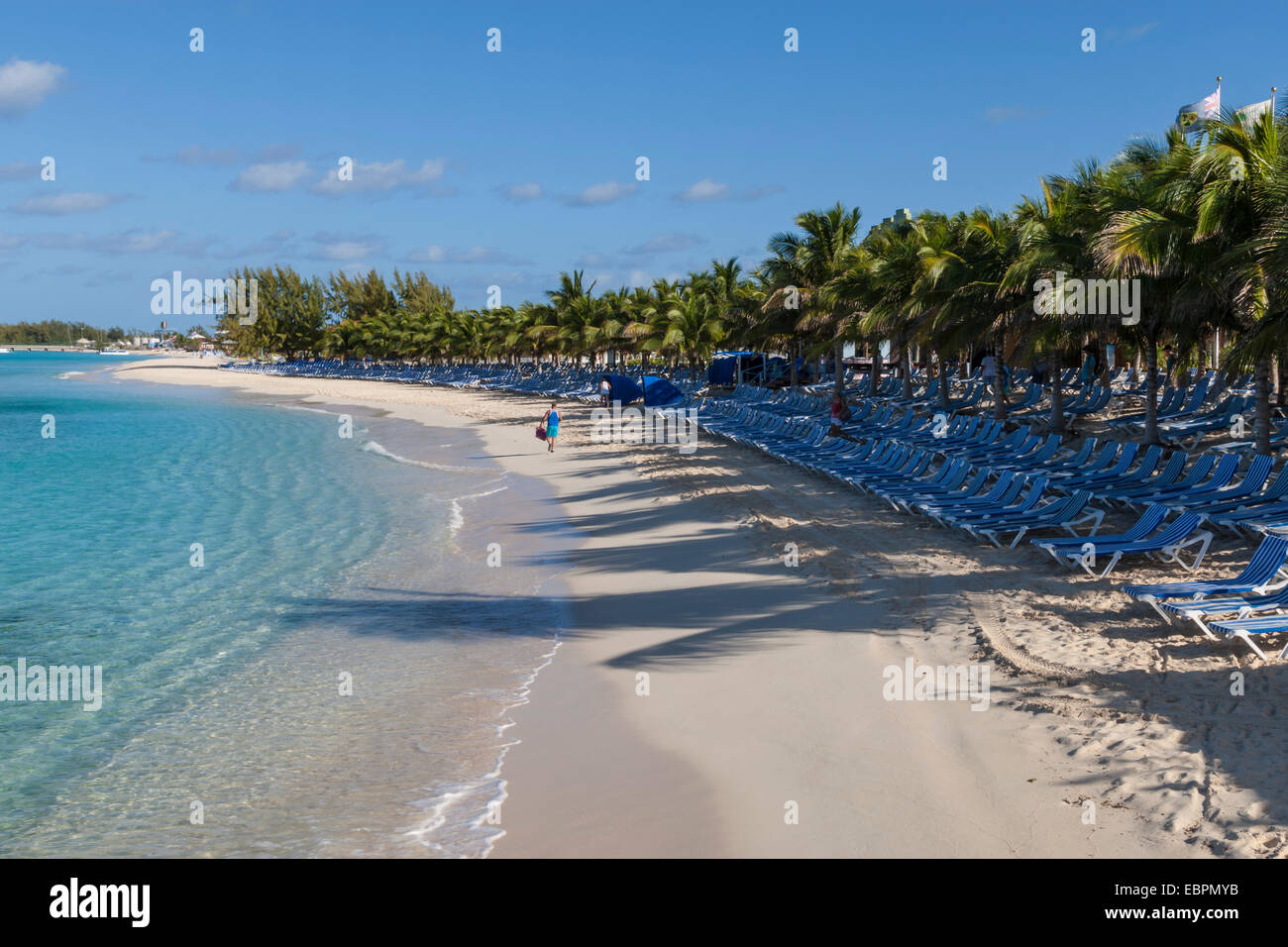 Turista su una spiaggia di sabbia bianca, palme e vuoto di sedie a sdraio, Grand Turk, Turks e Caicos, West Indies, dei Caraibi Foto Stock
