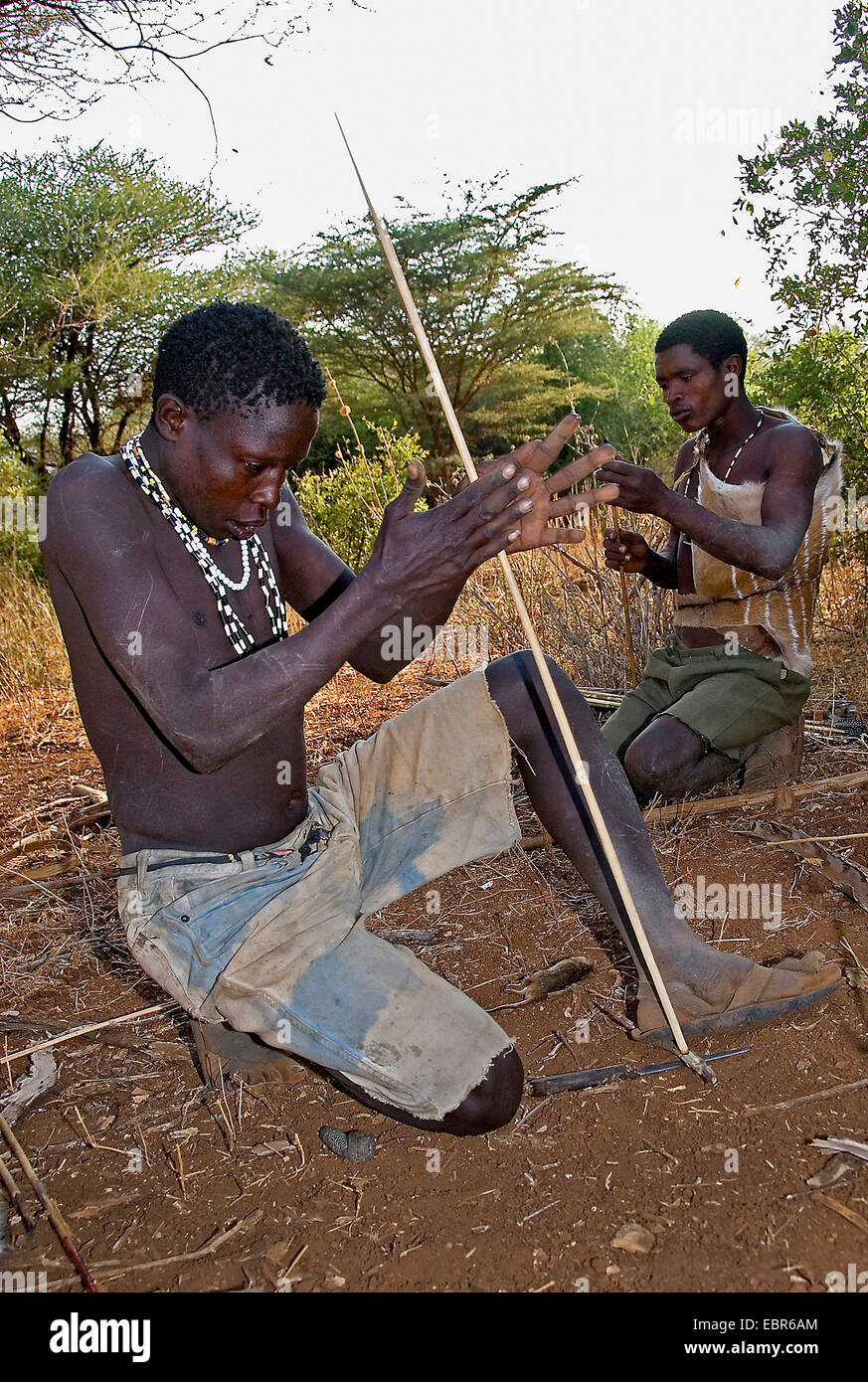 Hadzabe Boscimani che compongono il fuoco con un bastone, Tanzania Foto Stock