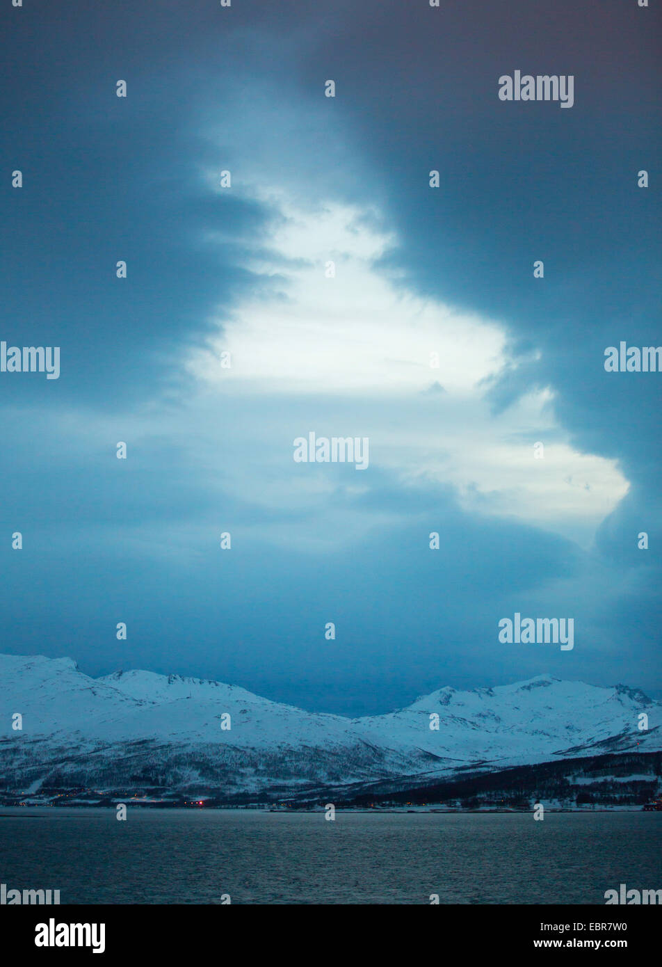 Il cloud foro sopra innevato paesaggio di montagna, Norvegia, Troms, Tromsoe Foto Stock