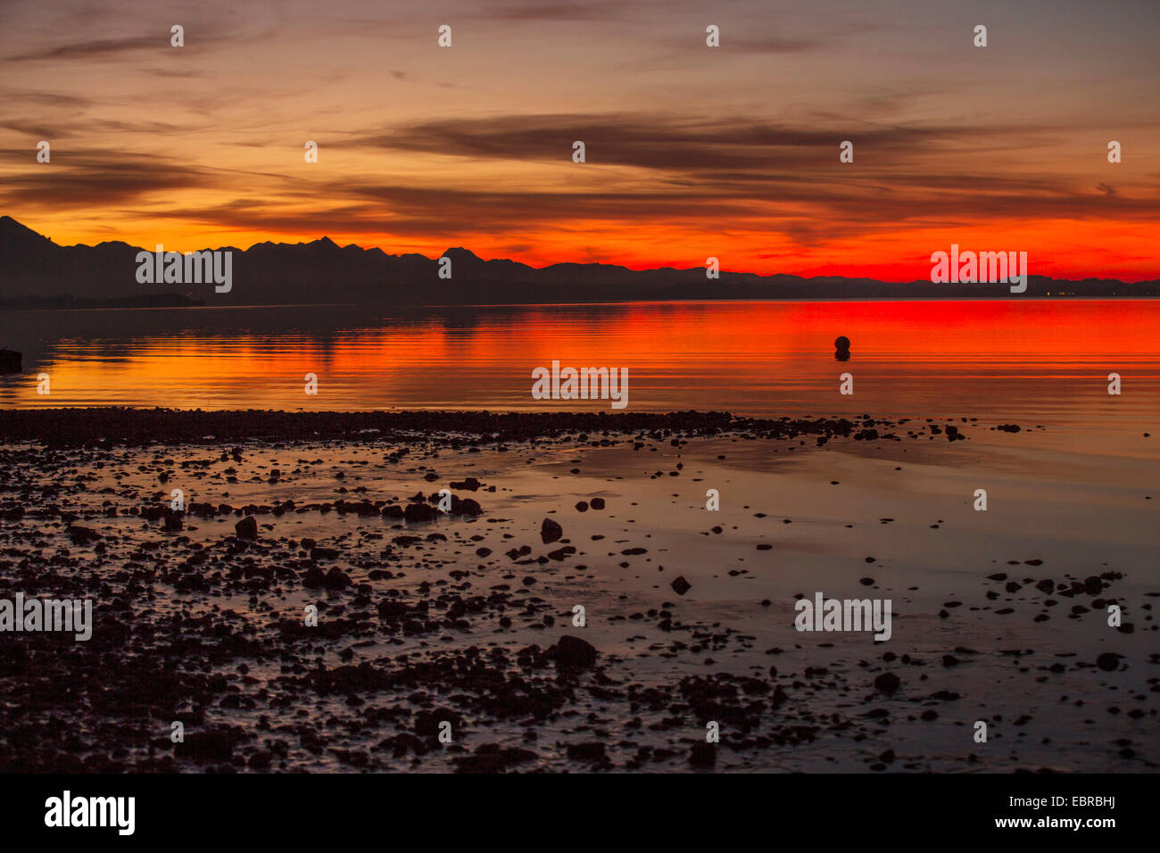 Bagliore di sera oltre il Chiemsee nella parte anteriore del panorama alpino, in Germania, in Baviera Foto Stock