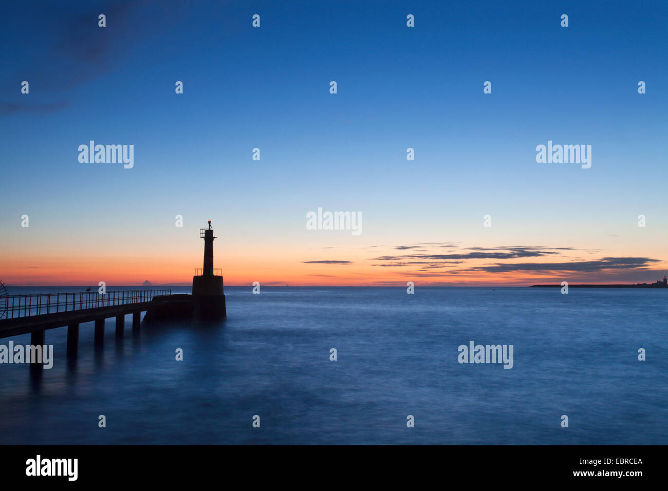 Luce del porto all'alba camminare sul mare Northumberland Inghilterra Foto Stock