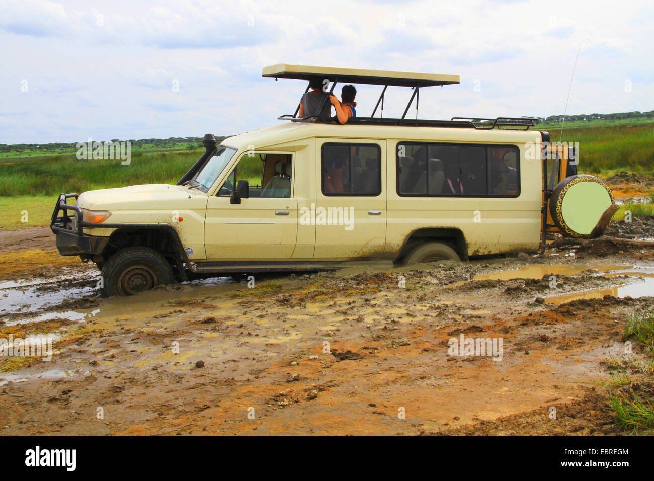Safari auto veloci bloccata nel fango, turisti in attesa di aiutare, Tanzania Serengeti National Park Foto Stock