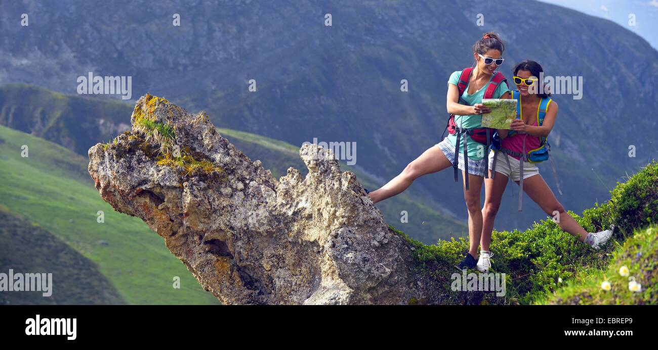 Due giovani donne wanderers su uno sperone di roccia guardando una mappa, Francia, Savoie, Parco Nazionale della Vanoise Foto Stock